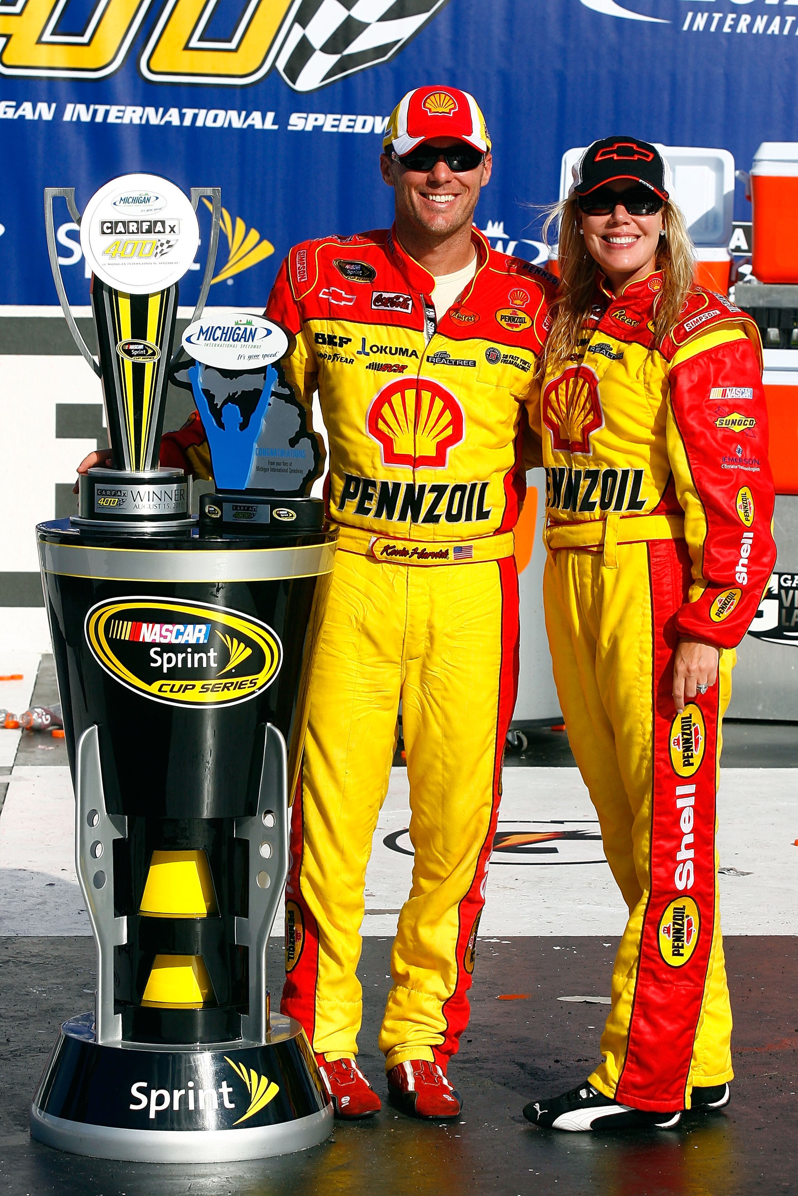 BROOKLYN, MI - AUGUST 15:  (L-R) Kevin Harvick, driver of the #29 Shell / Pennzoil Chevrolet and his wife DeLana celebrate with the trophy in victory lane after Keivn won the NASCAR Sprint Cup Series CARFAX 400 at Michigan International Speedway on August
