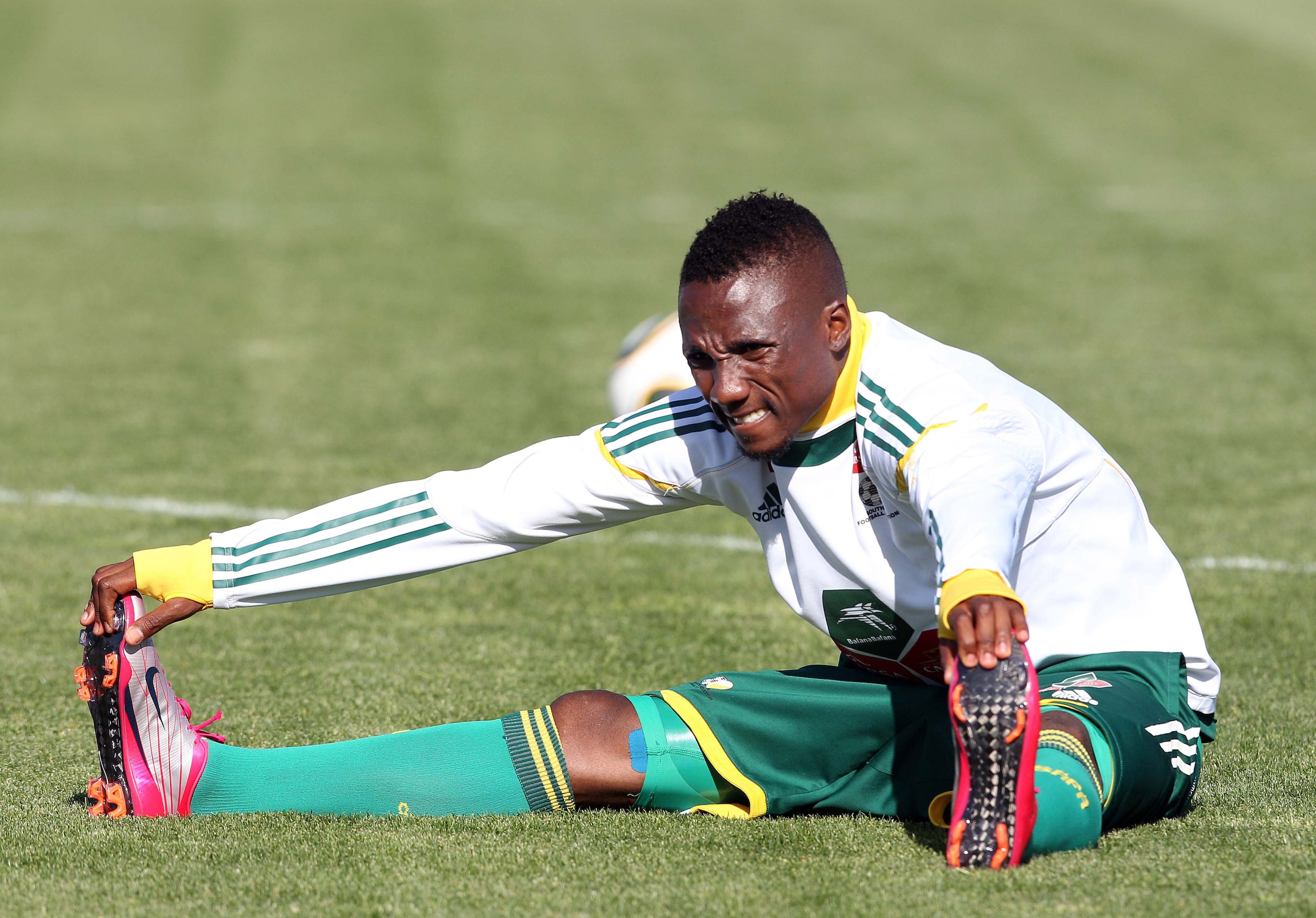 CAPE TOWN, SOUTH AFRICA - NOVEMBER 15:  Teko Modise of South Africa stretches during a South Africa team training session ahead of the Nelson Mandela Challenge Cup match against the USA at the Philippi Stadium on November 15, 2010 in Cape Town, South Afri