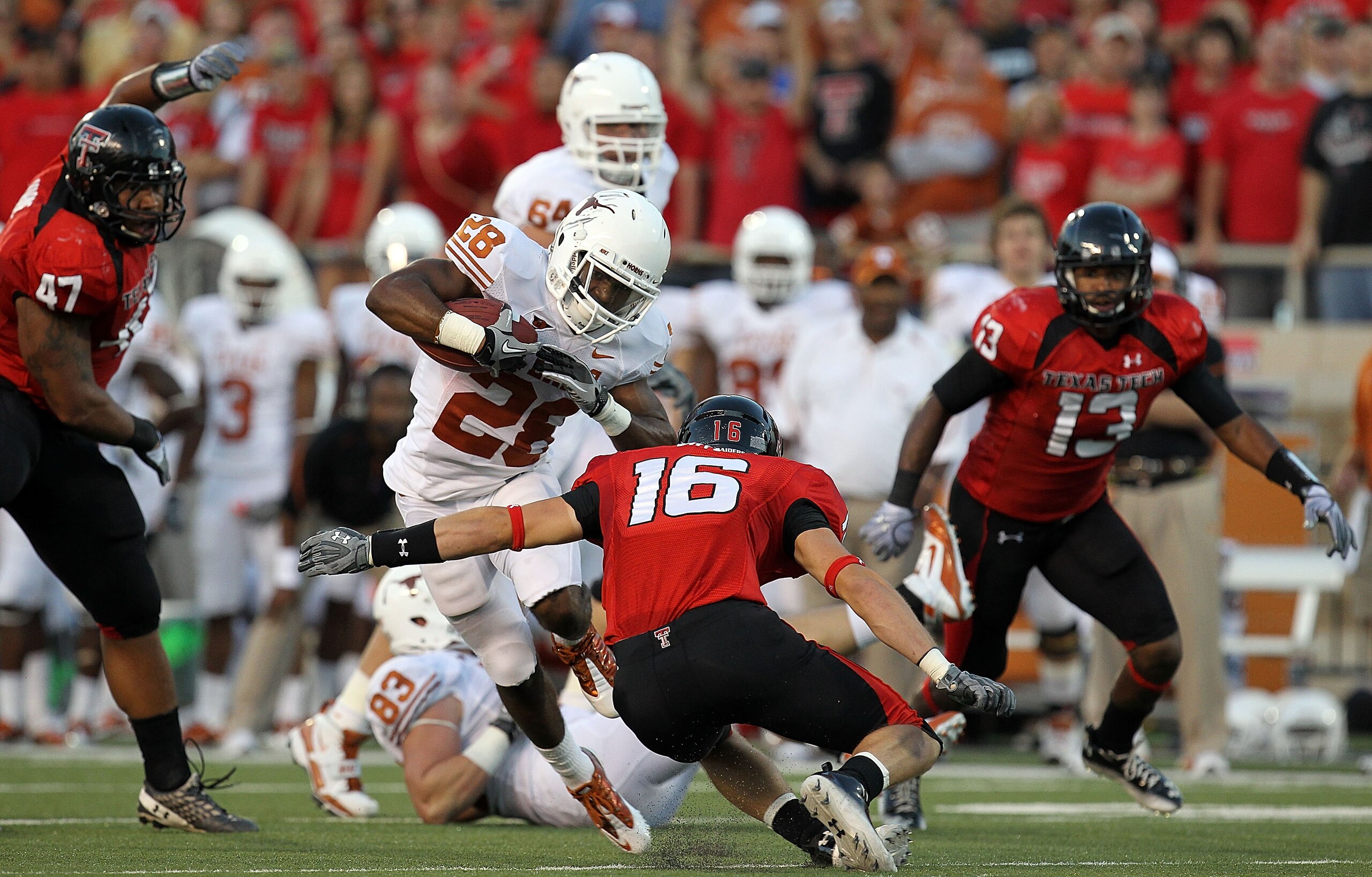 LUBBOCK, TX - SEPTEMBER 18:  Running back Foswhitt Whittaker #28 of the Texas Longhorns runs the ball past Cody Davis #16 of the Texas Tech Red Raiders at Jones AT&T Stadium on September 18, 2010 in Lubbock, Texas.  (Photo by Ronald Martinez/Getty Images)