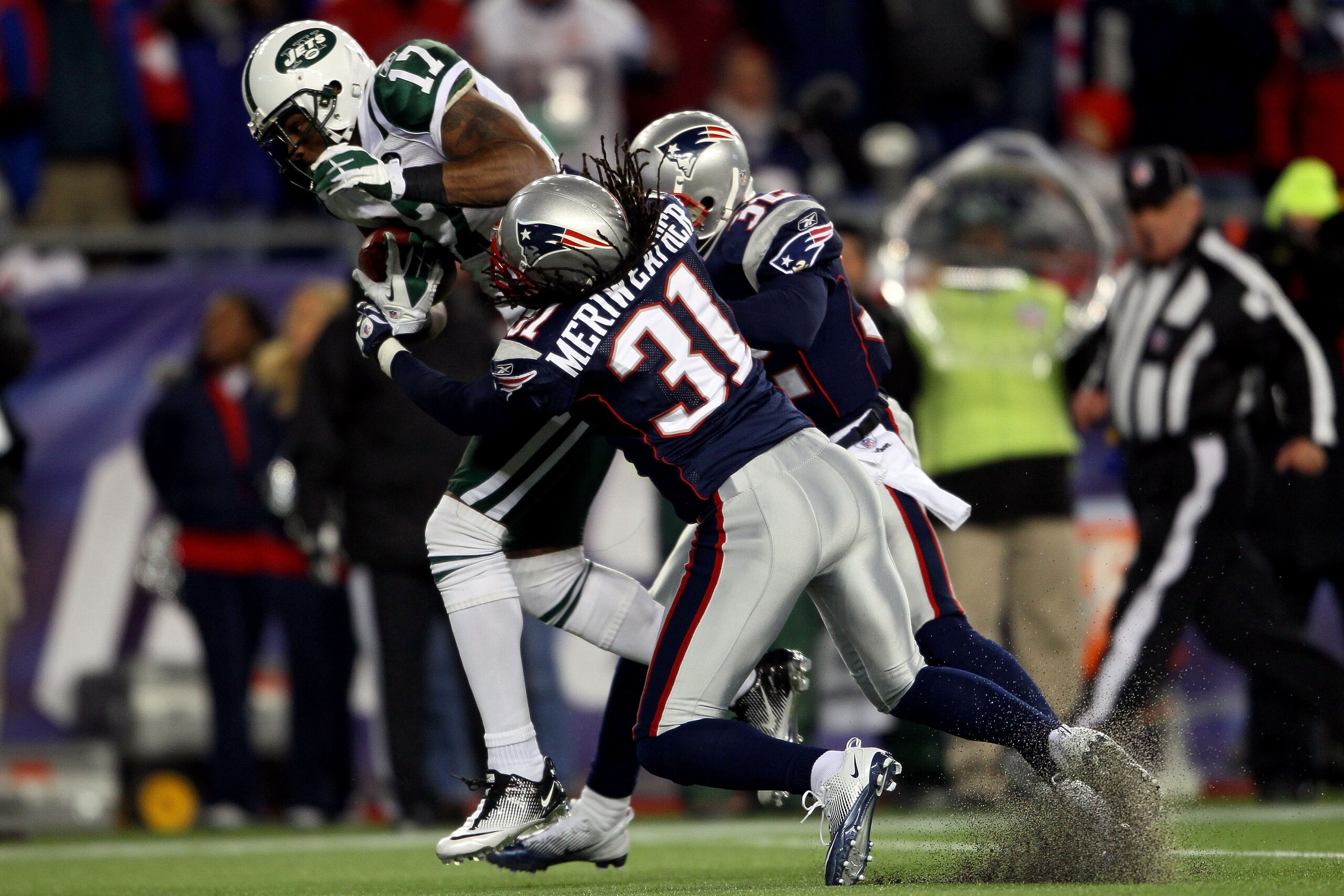 FOXBORO, MA - JANUARY 16:  Braylon Edwards #17 of the New York Jets scores a second quarter touchdown as Devin McCourty #32 and Brandon Meriweather #31 of the New England Patriots attempt to tackle during their 2011 AFC divisional playoff game at Gillette