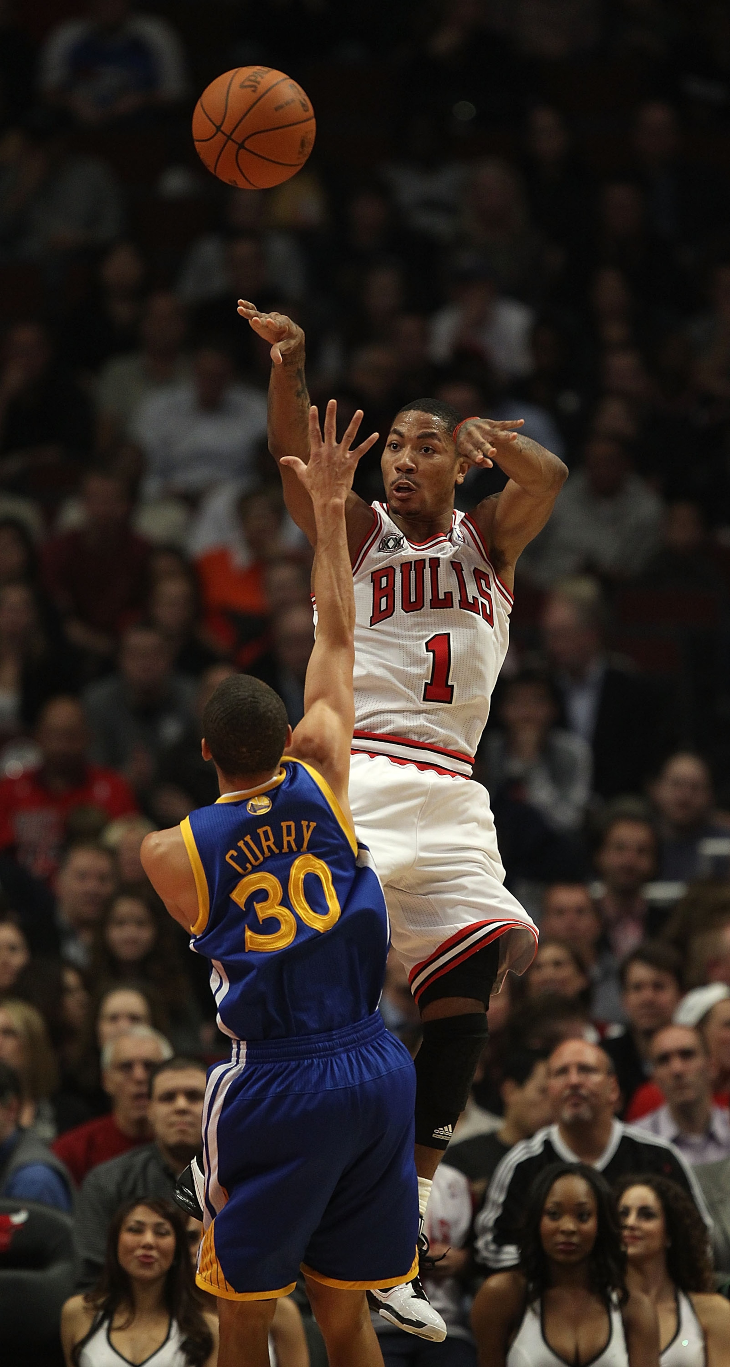 CHICAGO - NOVEMBER 11: Derrick Rose #1 of the Chicago Bulls leaps to pass the ball over Stephen Curry #30 of the Golden State Warriors at the United Center on November 11, 2010 in Chicago, Illinois. NOTE TO USER: User expressly acknowledges and agrees tha
