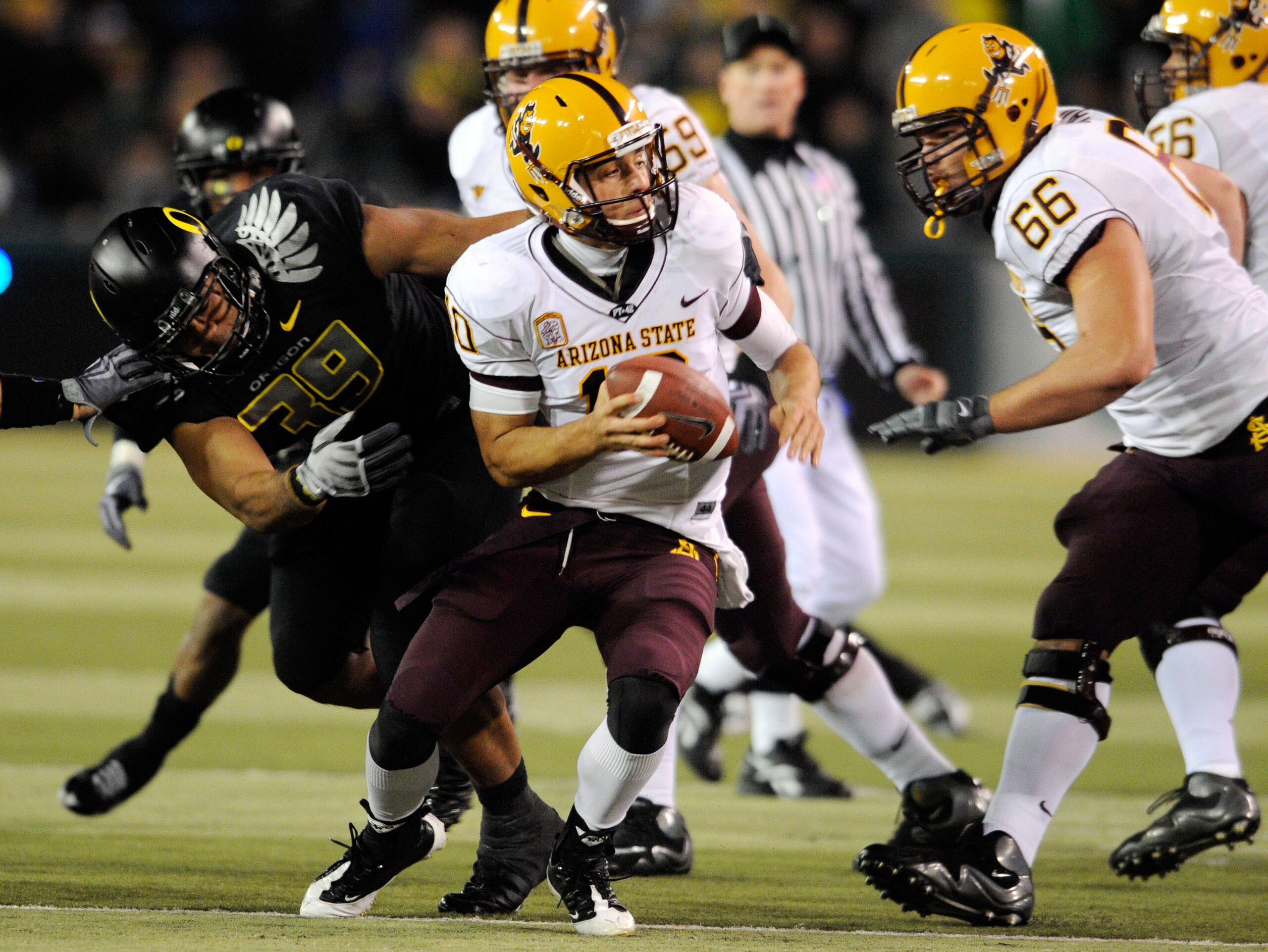 EUGENE,OR - NOVEMBER 14: Quarterback Samson Szakacsy #10 of the Arizona State Sun Devils avoids the rush of defensive end Will Tukuafu #39 of the Oregon Ducks in the third quarter of the game at Autzen Stadium on November 14, 2009 in Eugene, Oregon. Orego