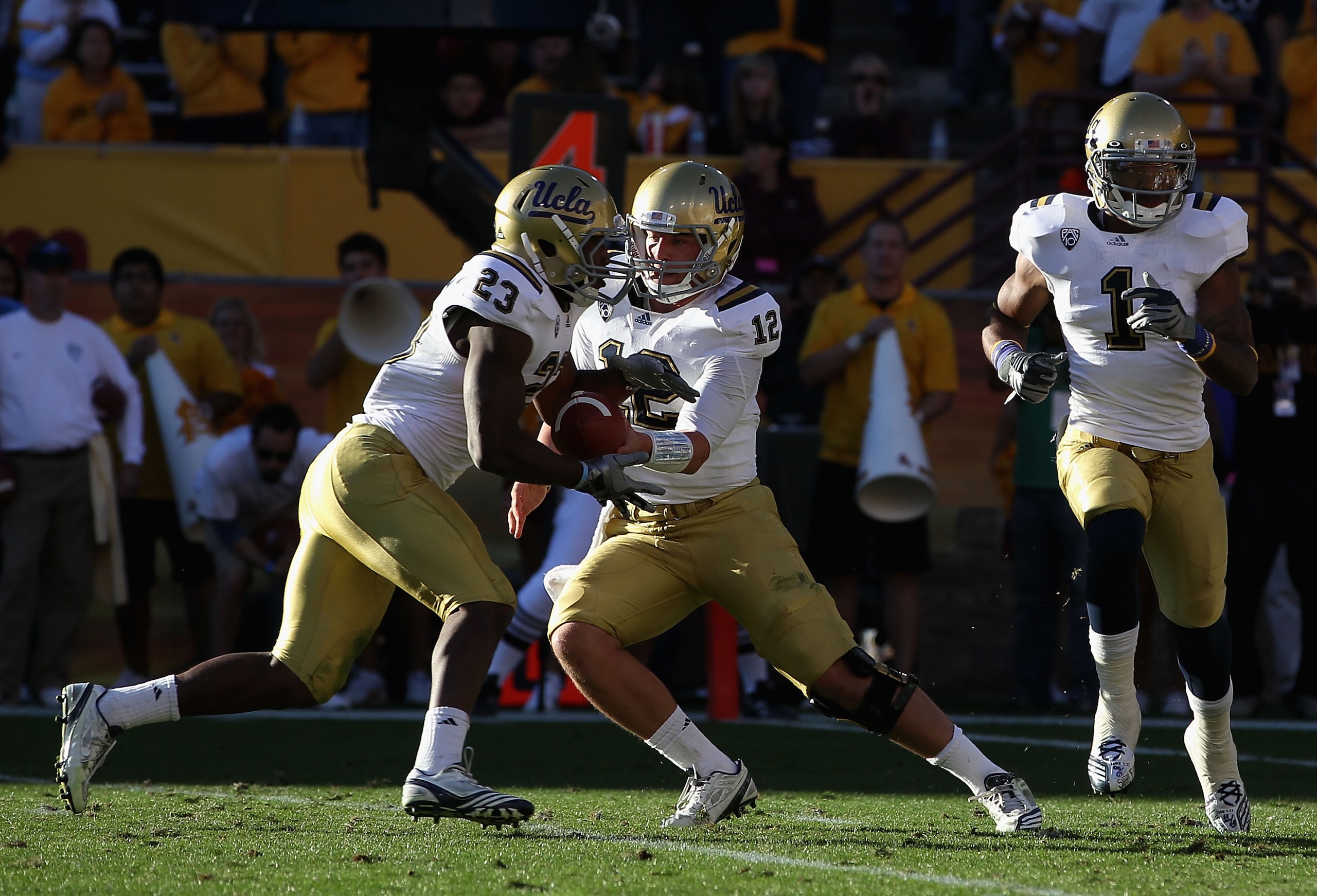 TEMPE, AZ - NOVEMBER 26:  Quarterback Richard Brehaut #12 of the UCLA Bruins hands off the football to Johnathan Franklin #23 during the college football game against the Arizona State Sun Devils at Sun Devil Stadium on November 26, 2010 in Tempe, Arizona