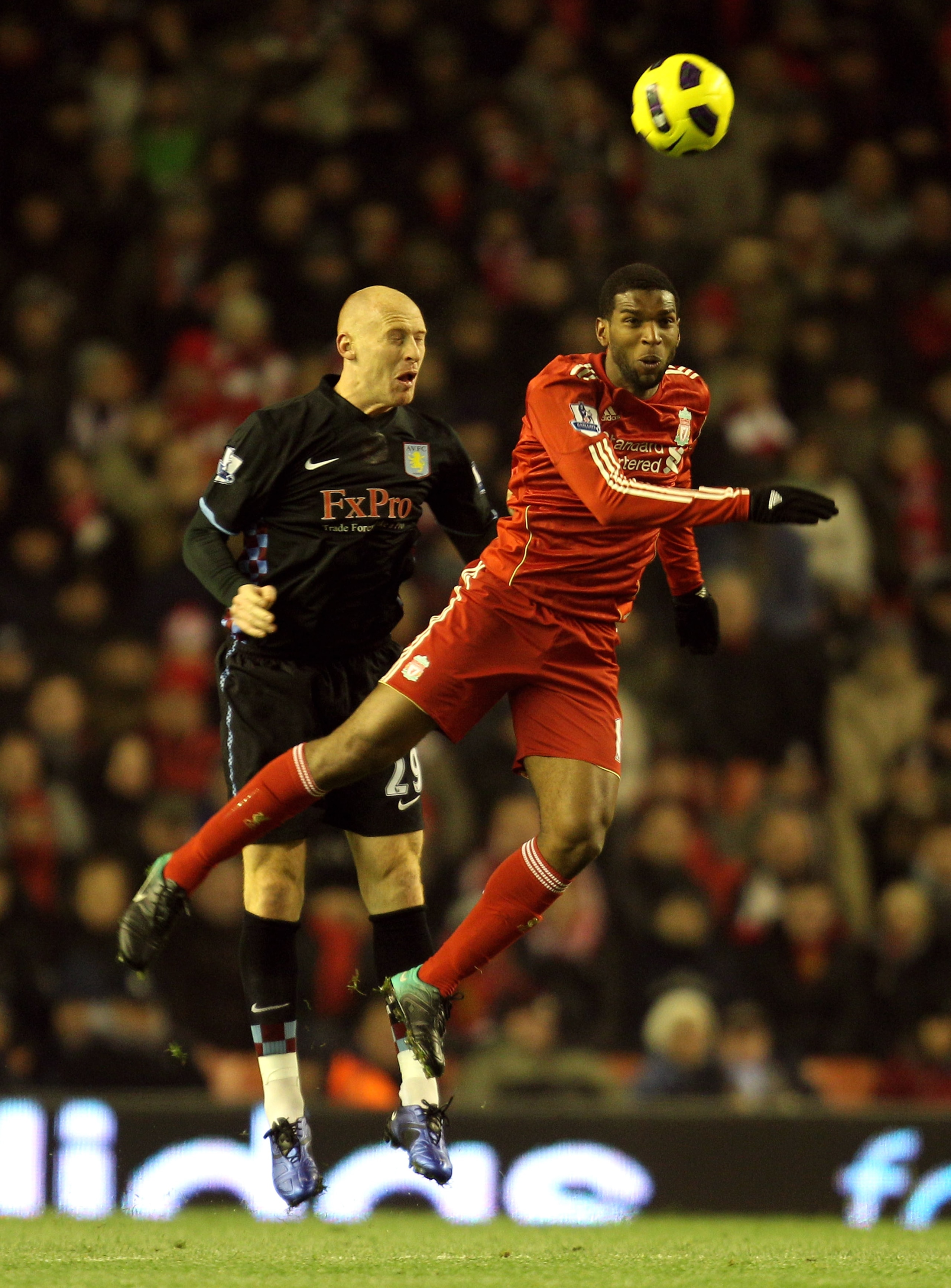 LIVERPOOL, ENGLAND - DECEMBER 06:  Ryan Babel of Liverpool goes up for a header with James Collins of Aston Villa during the Barclays Premier League match between Liverpool and Aston Villa at Anfield on December 6, 2010 in Liverpool, England. (Photo by Ma