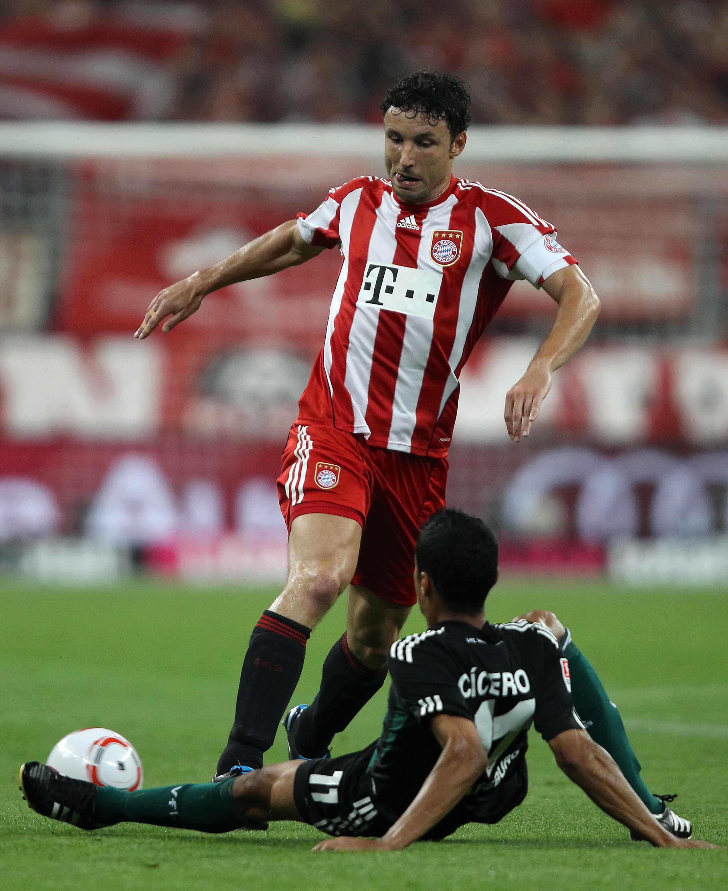 MUNICH, GERMANY - AUGUST 20: Mark van Bommel of Bayern is challenged by Cicero of Wolfsburg during the Bundesliga match between FC Bayern Muenchen and VfL Wolfsburg at Allianz Arena on August 20, 2010 in Munich, Germany.  (Photo by Clive Brunskill/Getty I