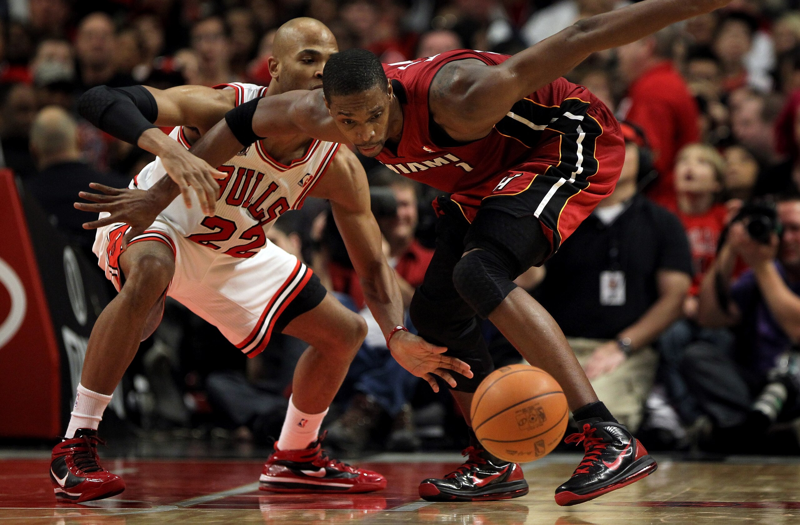 CHICAGO, IL - JANUARY 15:  Chris Bosh #1 of the Miami Heat battles for a loose ball with Taj Gibson #22 of the Chicago Bulls at the United Center on January 15, 2011 in Chicago, Illinois. The Bulls defeated the Heat 99-96. NOTE TO USER: User expressly ack