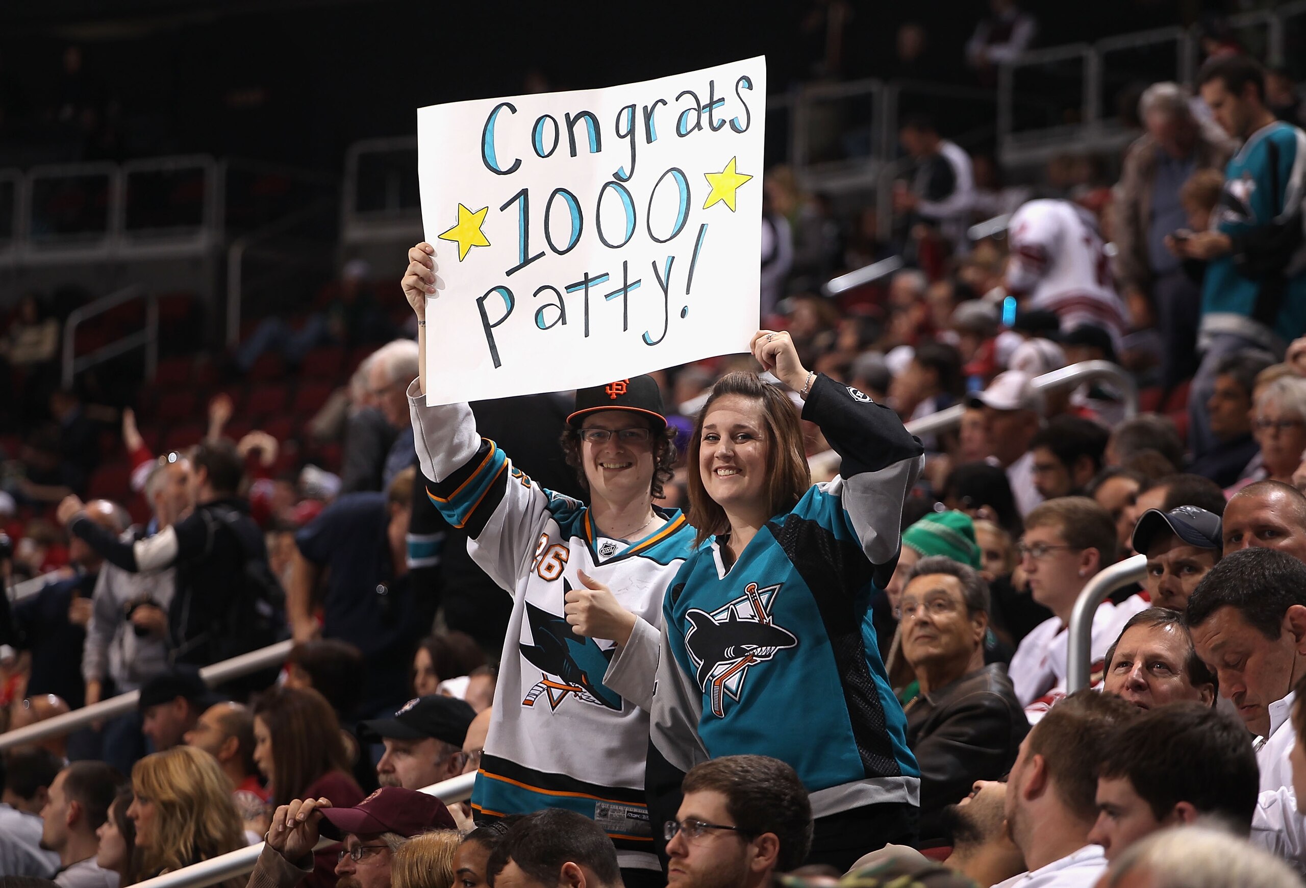 GLENDALE, AZ - JANUARY 17:  Fans of the San Jose Sharks hold up a sign in honor of Patrick Marleau (not pictured) playing in his 1,000th career game during the NHL game against the Phoenix Coyotes at Jobing.com Arena on January 17, 2011 in Glendale, Arizo