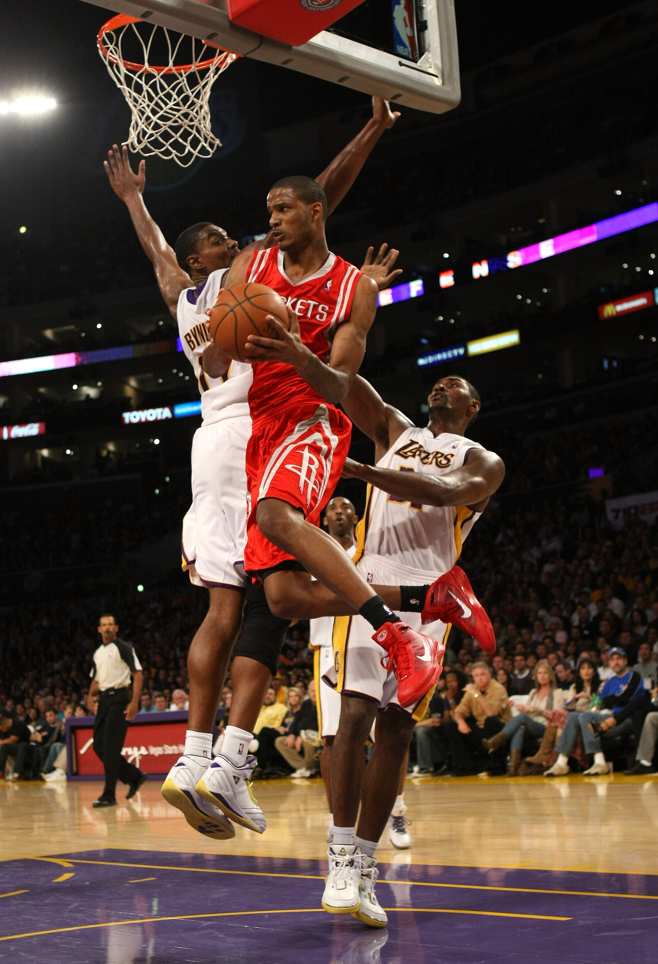 LOS ANGELES - NOVEMBER 15: Trevor Ariza #1 of  the Houston Rockets jumps through the lane between Ron Artest #37 and Andrew Bynum #17 of the Los Angeles Lakers on November 15, 2009 at Staples Center in Los Angeles, California.  The Rockets won 101-91.  NO