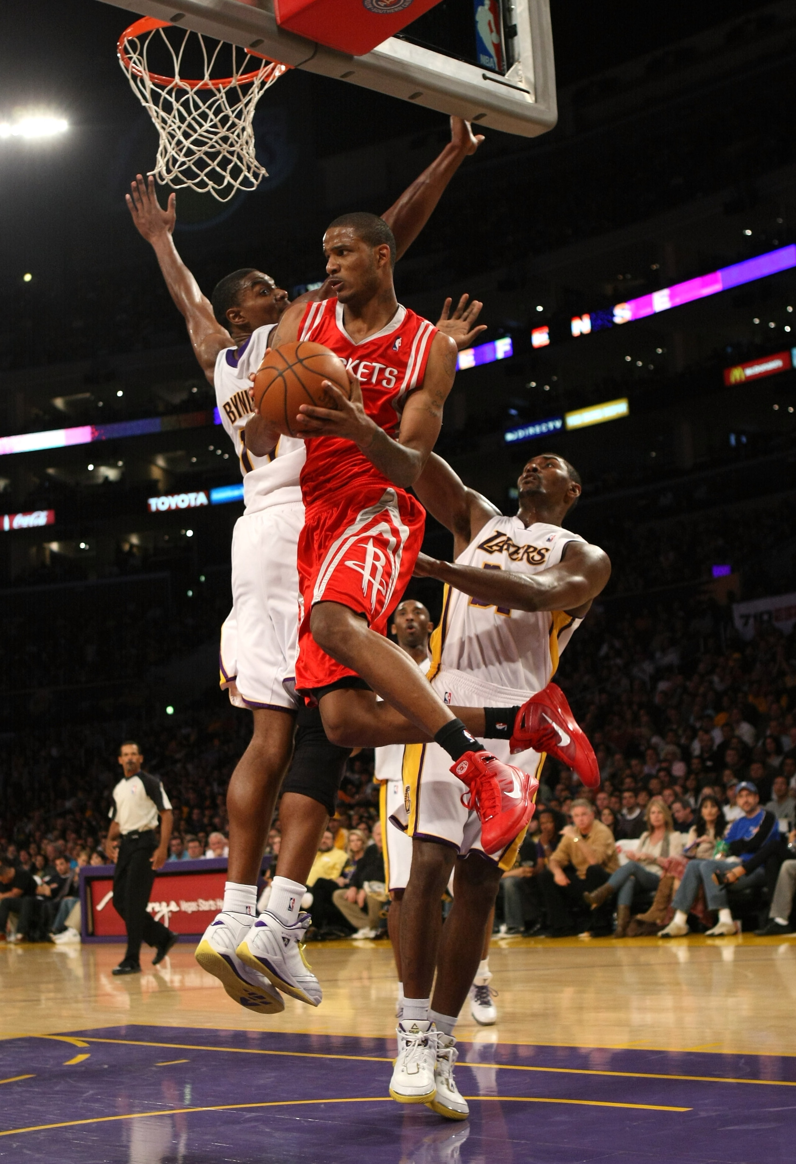 LOS ANGELES - NOVEMBER 15: Trevor Ariza #1 of  the Houston Rockets jumps through the lane between Ron Artest #37 and Andrew Bynum #17 of the Los Angeles Lakers on November 15, 2009 at Staples Center in Los Angeles, California.  The Rockets won 101-91.  NO