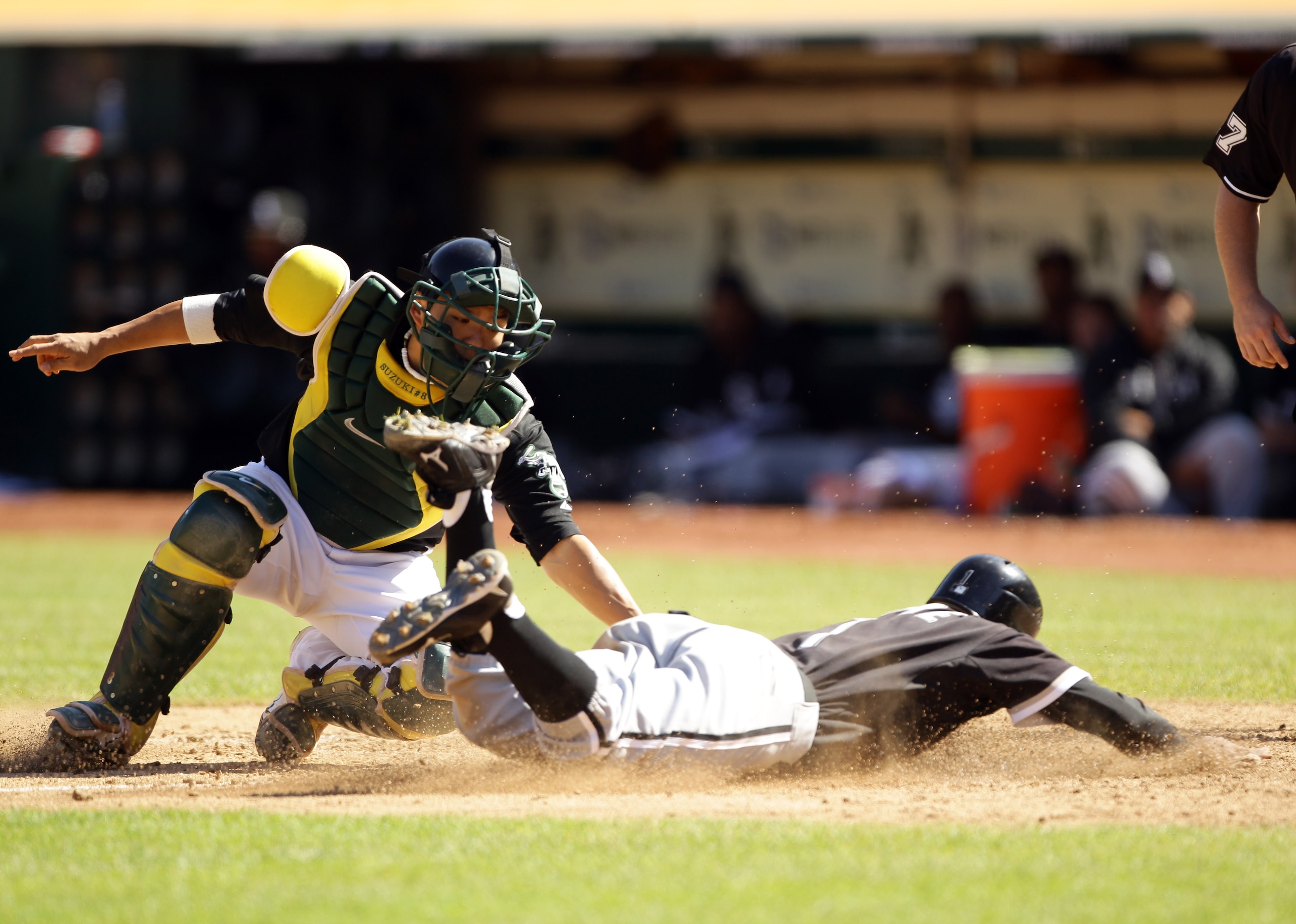 OAKLAND, CA - SEPTEMBER 22:  Juan Pierre #1 of the Chicago White Sox slides past Kurt Suzuki #8 of the Oakland Athletics to score in the eighth inning at the Oakland-Alameda County Coliseum on September 22, 2010 in Oakland, California.  (Photo by Ezra Sha