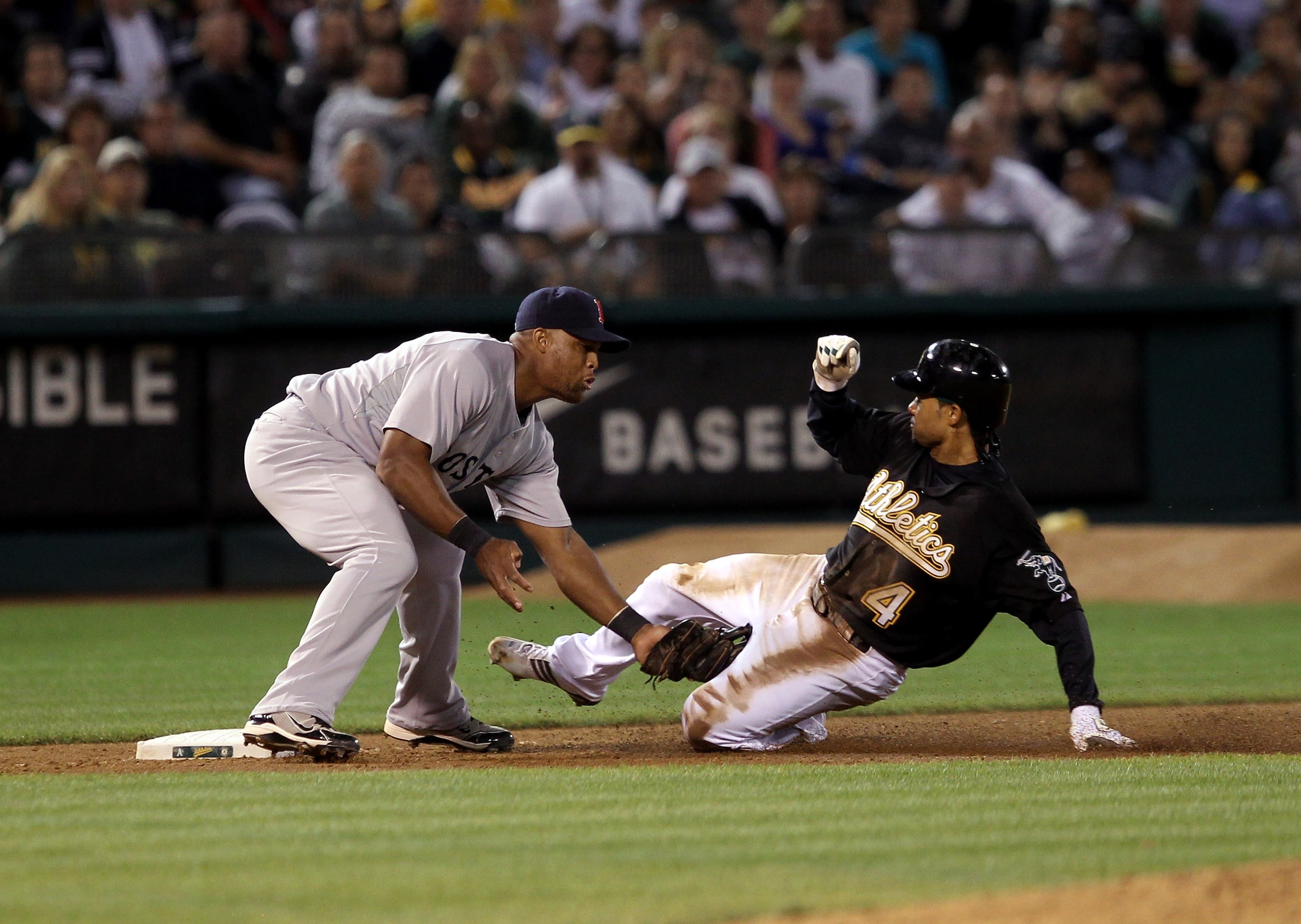 OAKLAND, CA - SEPTEMBER 10:  Coco Crisp #4 of the Oakland Athletics is tagged out by Adrian Beltre #29 of the Boston Red Sox after Crisp tried to reach third base after tagging up on a fly out to center field at the Oakland-Alameda County Coliseum on Sept