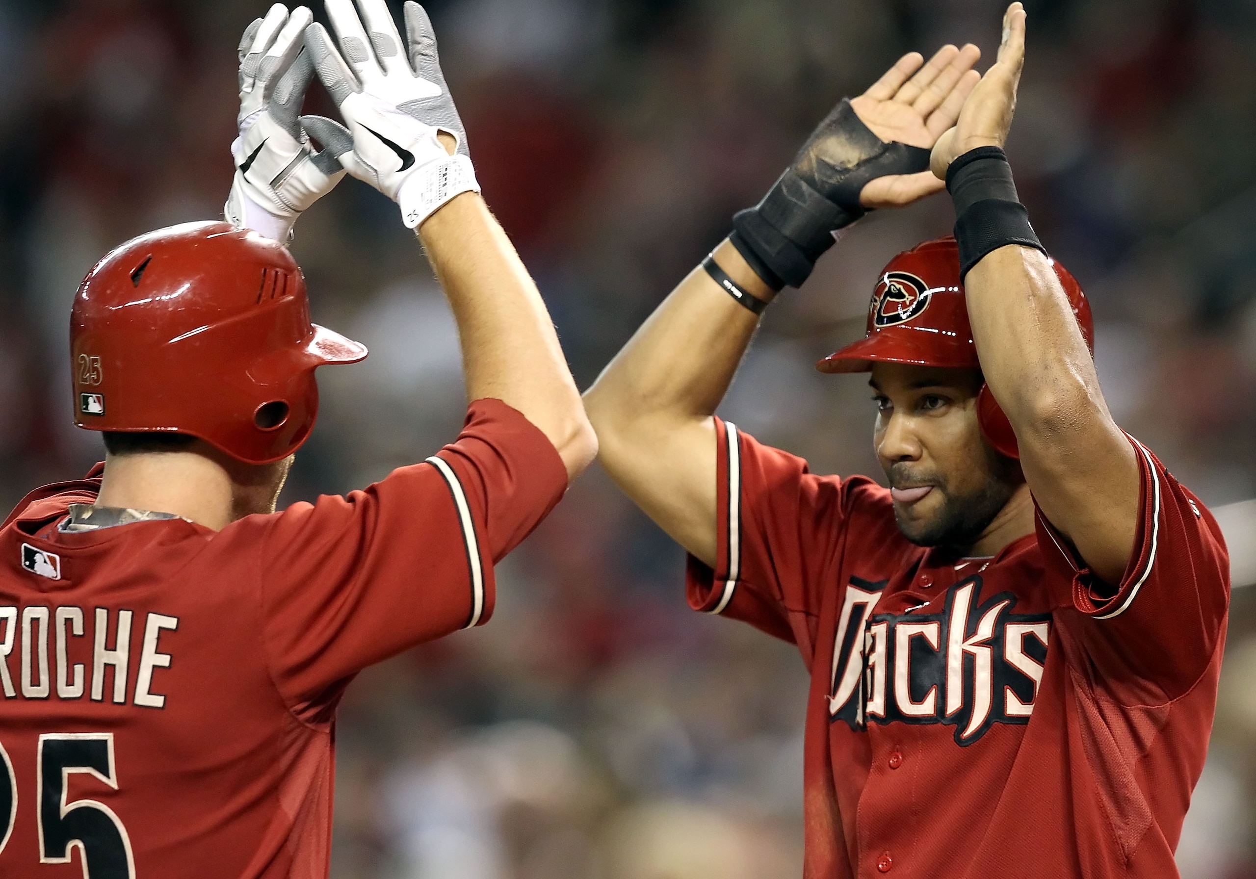 PHOENIX - SEPTEMBER 22:  Chris Young #24 of the Arizona Diamondbacks high fives teammate Adam LaRoche #25 after LaRoche hit a 2 run home run against the Colorado Rockies during the third inning of the Major League Baseball game at Chase Field on September
