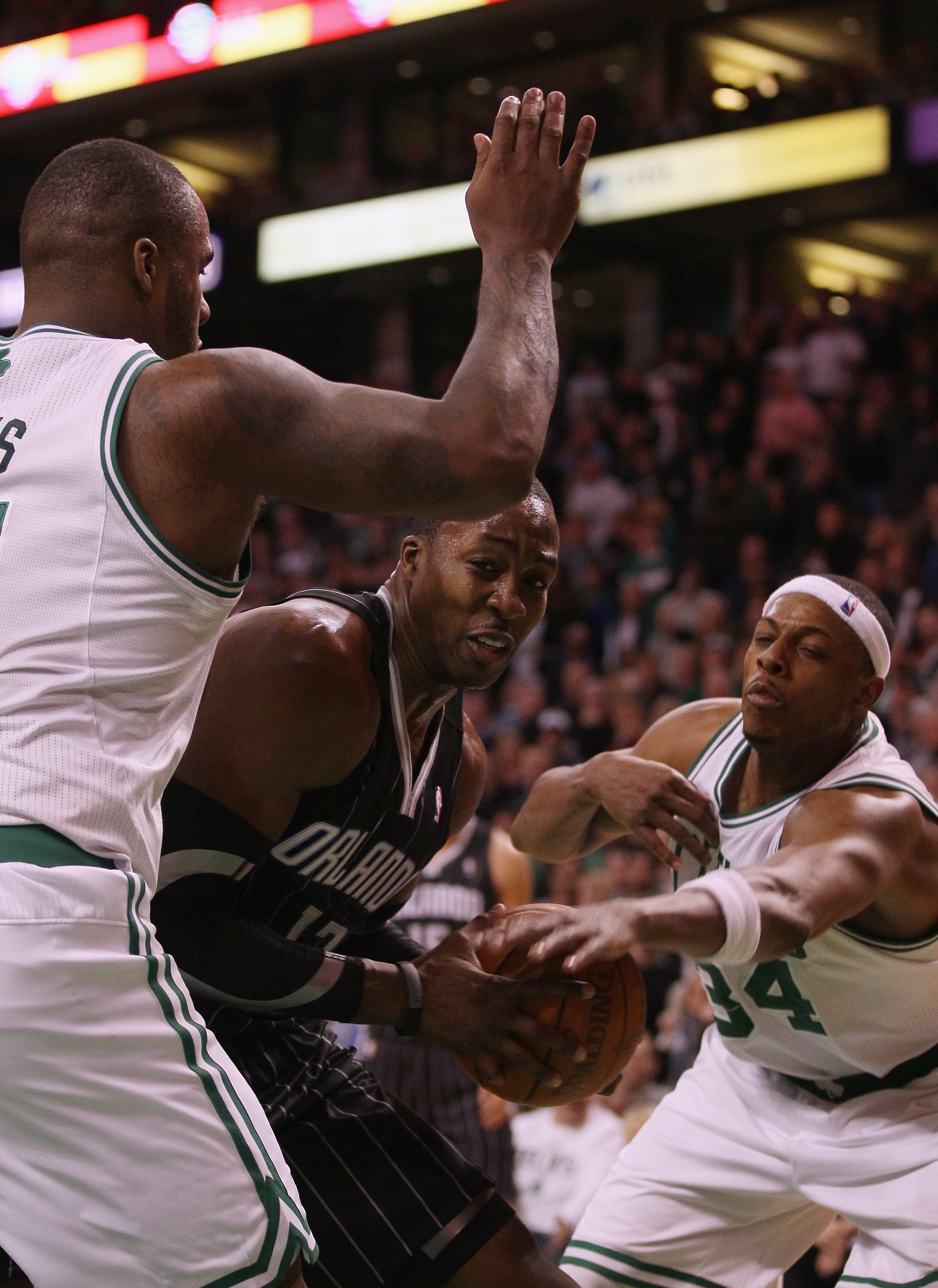 BOSTON, MA - JANUARY 17:   Dwight Howard #12 of the Orlando Magic tries to get past Glen Davis #11 and Paul Pierce #34 of the Boston Celtics  on January 17, 2011 at the TD Garden in Boston, Massachusetts. The Celtics defeated the Magic 109-106.  NOTE TO U
