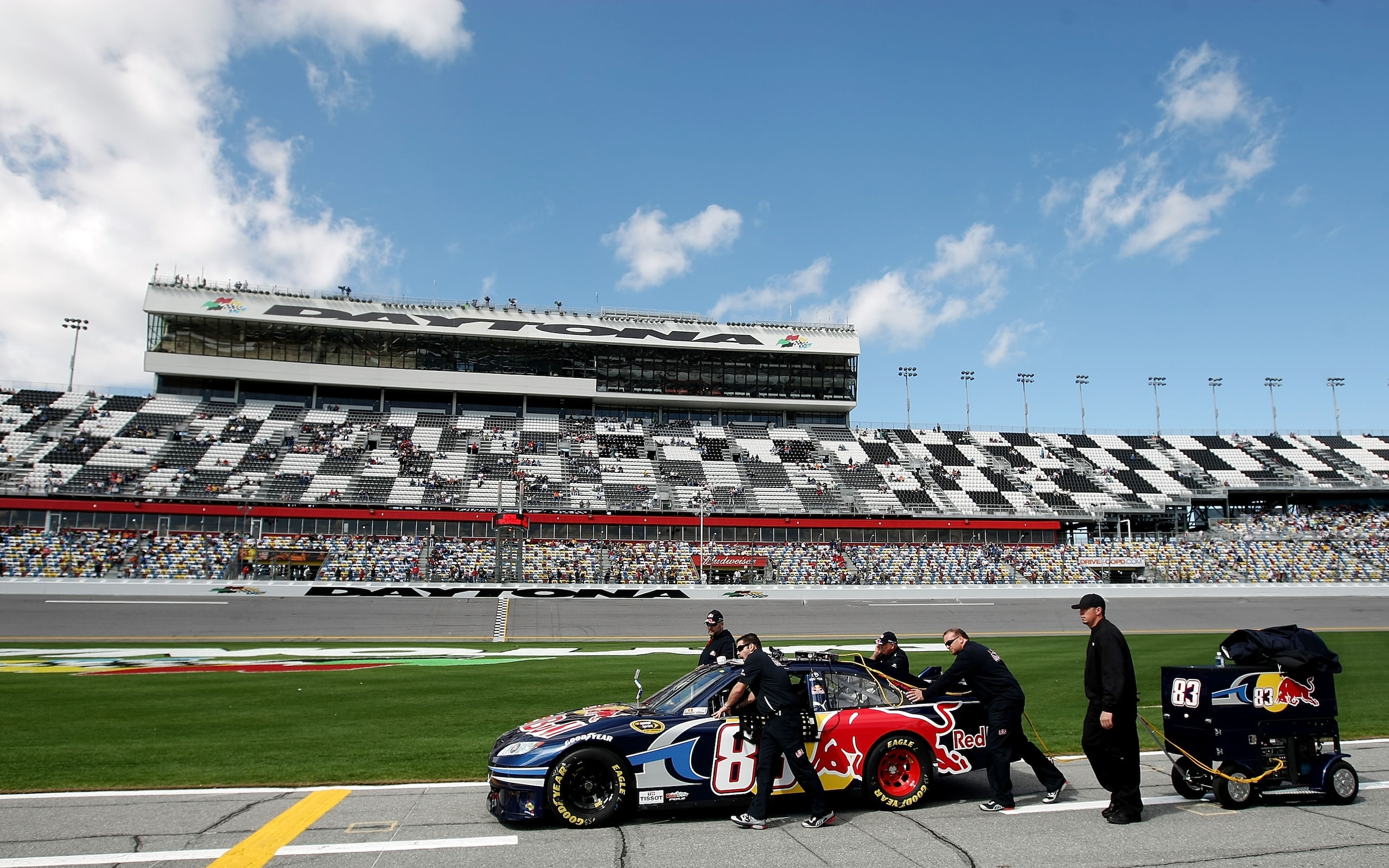 DAYTONA BEACH, FL - FEBRUARY 06:  Members of the #83 Red Bull Toyota team push the car on pit road during qualifying for the Daytona 500 at Daytona International Speedway on February 6, 2010 in Daytona Beach, Florida.  (Photo by Nick Laham/Getty Images)