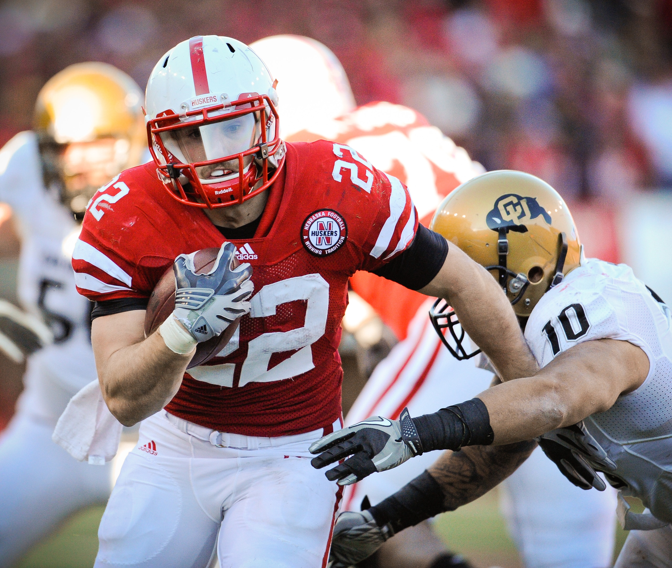 LINCOLN, NE - NOVEMBER 26: Rex Burkhead #22 of the Nebraska Cornhuskers runs past Michael Sipili #10 of the Colorado Buffaloes during the first half of their game at Memorial Stadium on November 26, 2010 in Lincoln, Nebraska.  (Photo by Eric Francis/Getty
