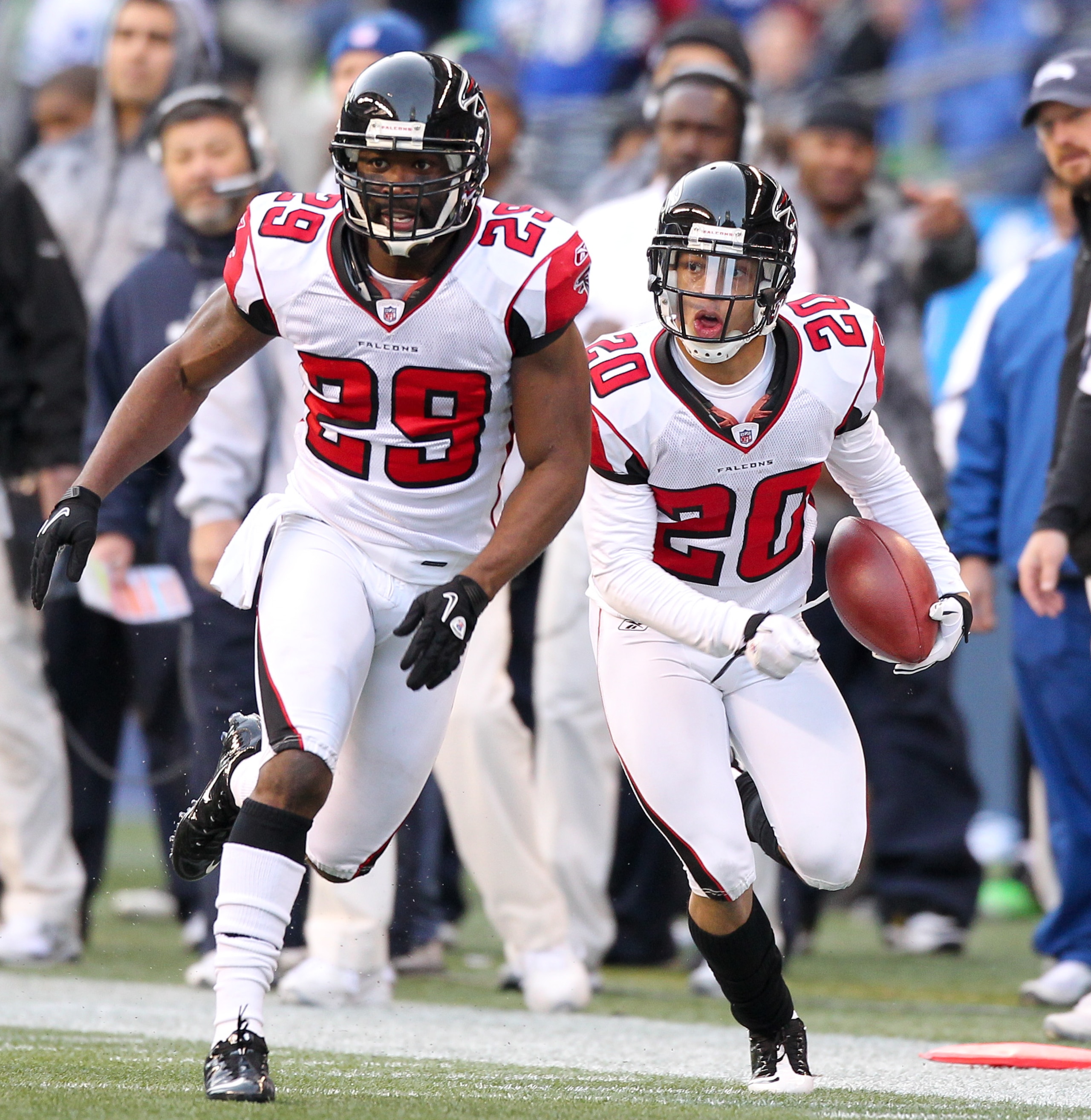 SEATTLE, WA - DECEMBER 19:  Brent Grimes #20 of the Atlanta Falcons returns an interception as Brian Williams #29 leads the block against the Seattle Seahawks at Qwest Field on December 19, 2010 in Seattle, Washington. The Falcons defeated the Seahawks 34