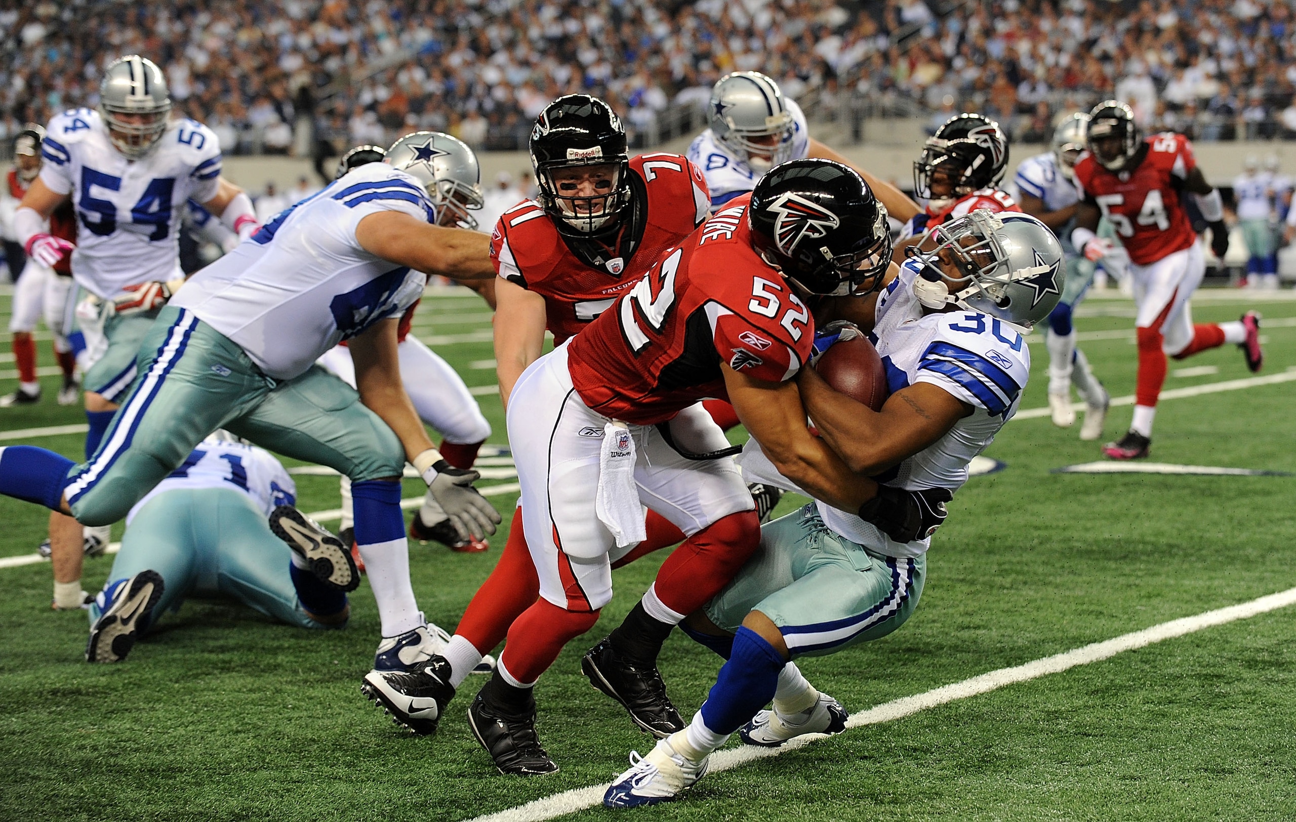 ARLINGTON, TX - OCTOBER 25:  Kickoff return specialist Allen Rossum #30 of the Dallas Cowboys is tackled by Coy Wire #52 of the Atlanta Falcons at Cowboys Stadium on October 25, 2009 in Arlington, Texas.  (Photo by Ronald Martinez/Getty Images)