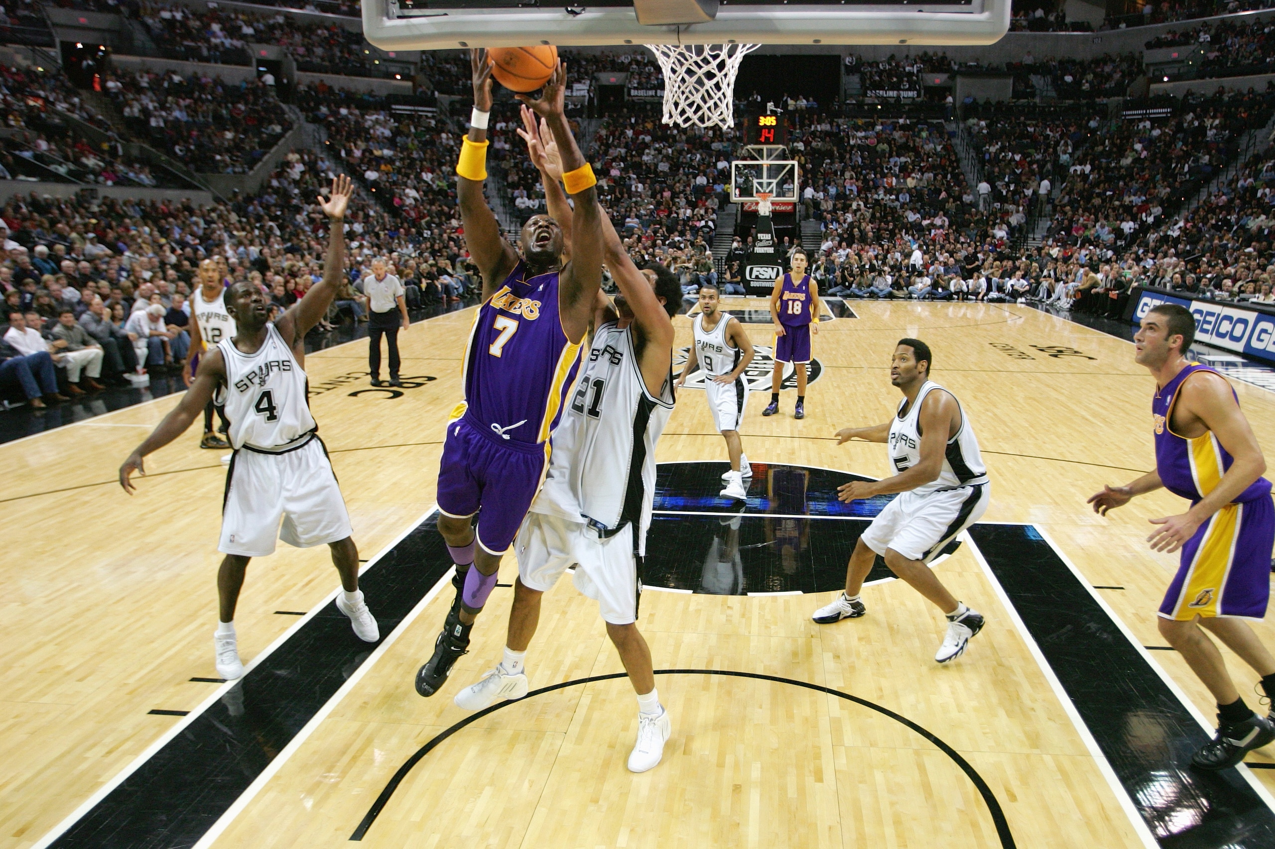SAN ANTONIO - NOVEMBER 29:  Lamar Odom #7 of the Los Angeles Lakers takes the ball to the basket past Tim Duncan #21 of the San Antonio Spurs during a game at SBC Center on November 29, 2005 in San Antonio, Texas.  The Spurs defeated the Lakers 90-84.  NO