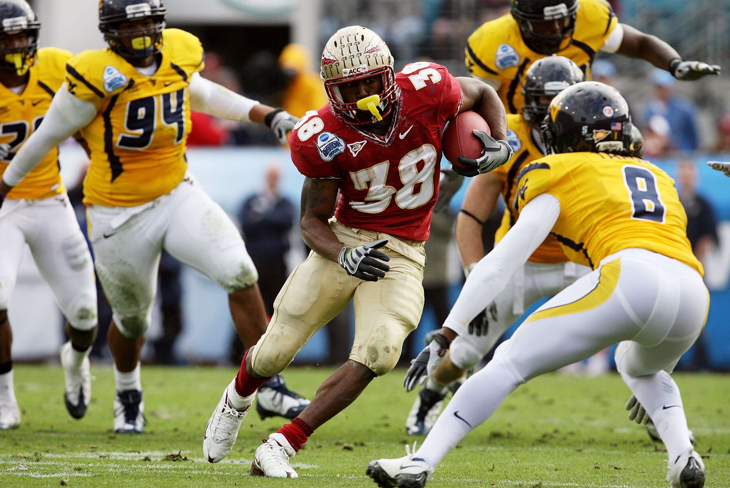 JACKSONVILLE, FL - JANUARY 01: Running back Jermaine Thomas #38 of the Florida State Seminoles looks to avoid a tackle attempt by defensive back Keith Tandy #8 of the West Virginia Mountaineers during the Konica Minolta Gator Bowl on January 1, 2010 in J JACKSONVILLE, FL - JANUARY 01: Running back Jermaine Thomas #38 of the Florida State Seminoles looks to avoid a tackle attempt by defensive back Keith Tandy #8 of the West Virginia Mountaineers during the Konica Minolta Gator Bowl on January 1, 2010 in J