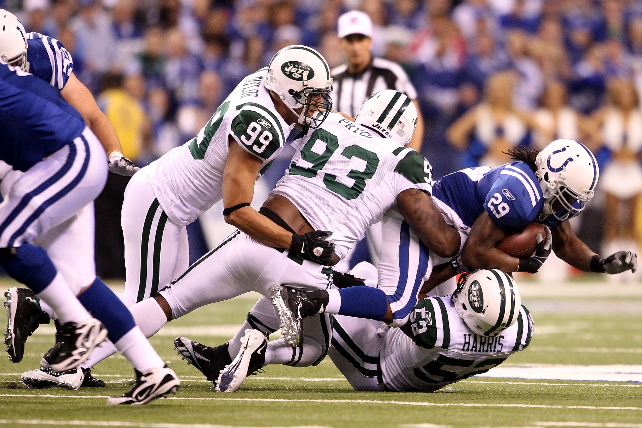 INDIANAPOLIS, IN - JANUARY 08:  Joseph Addai #29 of the Indianapolis Colts is tackled by Jason Taylor #99, Trevor Pryce #93 and David Harris #52 of the New York Jets during their 2011 AFC wild card playoff game at Lucas Oil Stadium on January 8, 2011 in I
