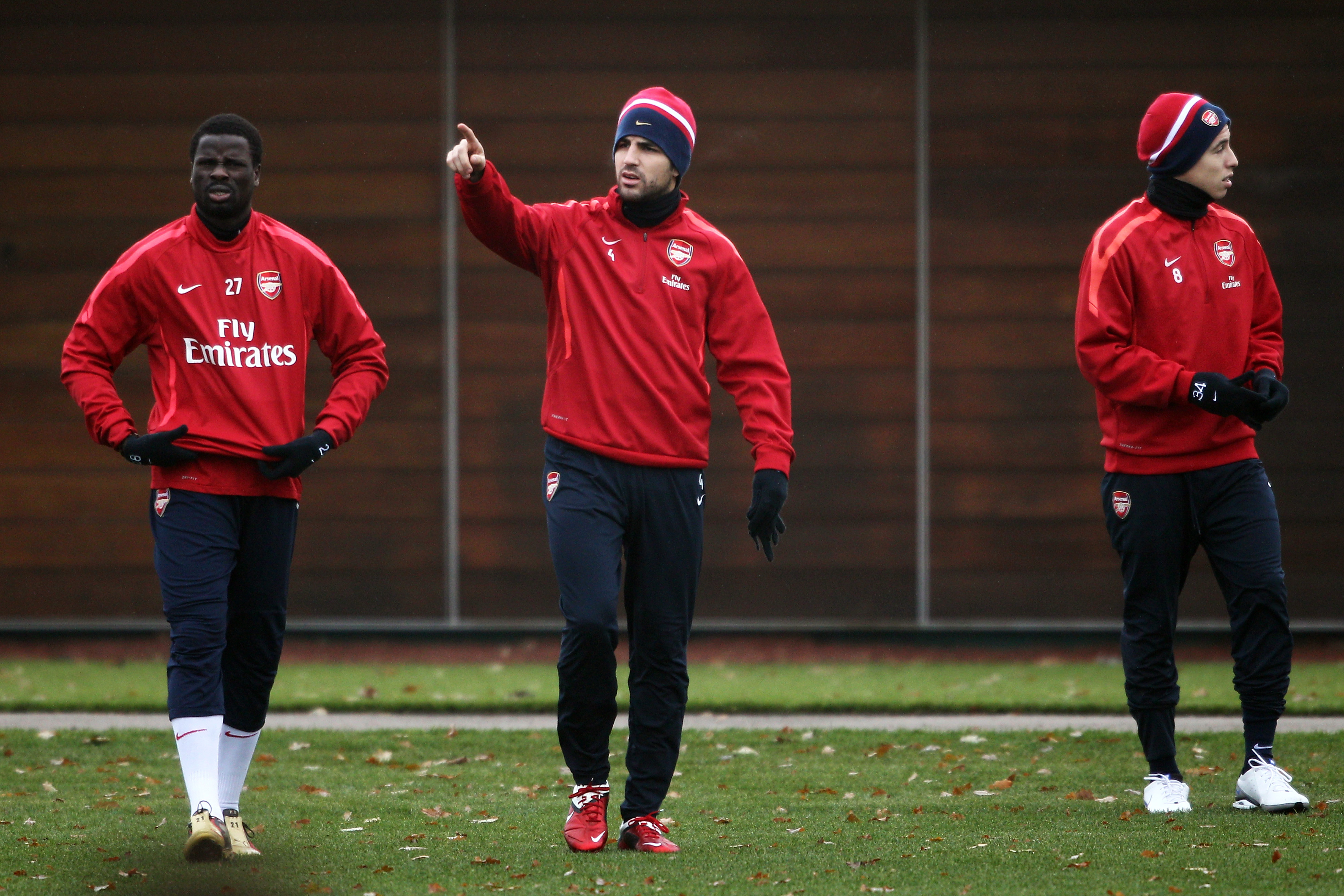 ST ALBANS, ENGLAND - DECEMBER 15:  Cesc Fabregas (C) speaks to Emmanuel Eboue (L) as they walk out to the Arsenal Training Session at London Colney on December 15, 2010 in St Albans, England.  (Photo by Dean Mouhtaropoulos/Getty Images)