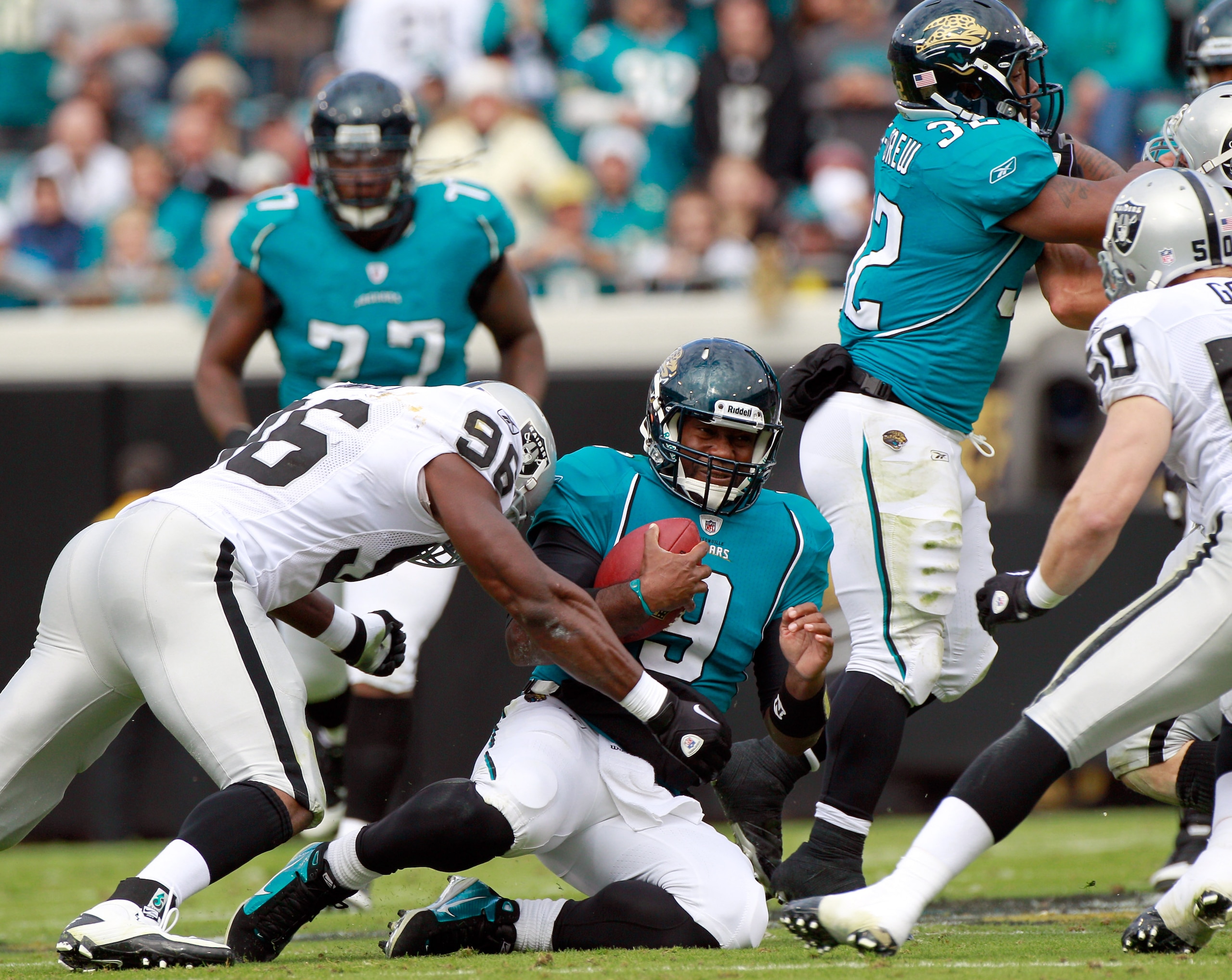 JACKSONVILLE, FL - DECEMBER 12: Quarterback David Garrard #9 of the Jacksonville Jaguars slides while being tackled by Kameron Wimbley #96 of the Oaklland Raiders during the game at EverBank Field on December 12, 2010 in Jacksonville, Florida.  (Photo by 