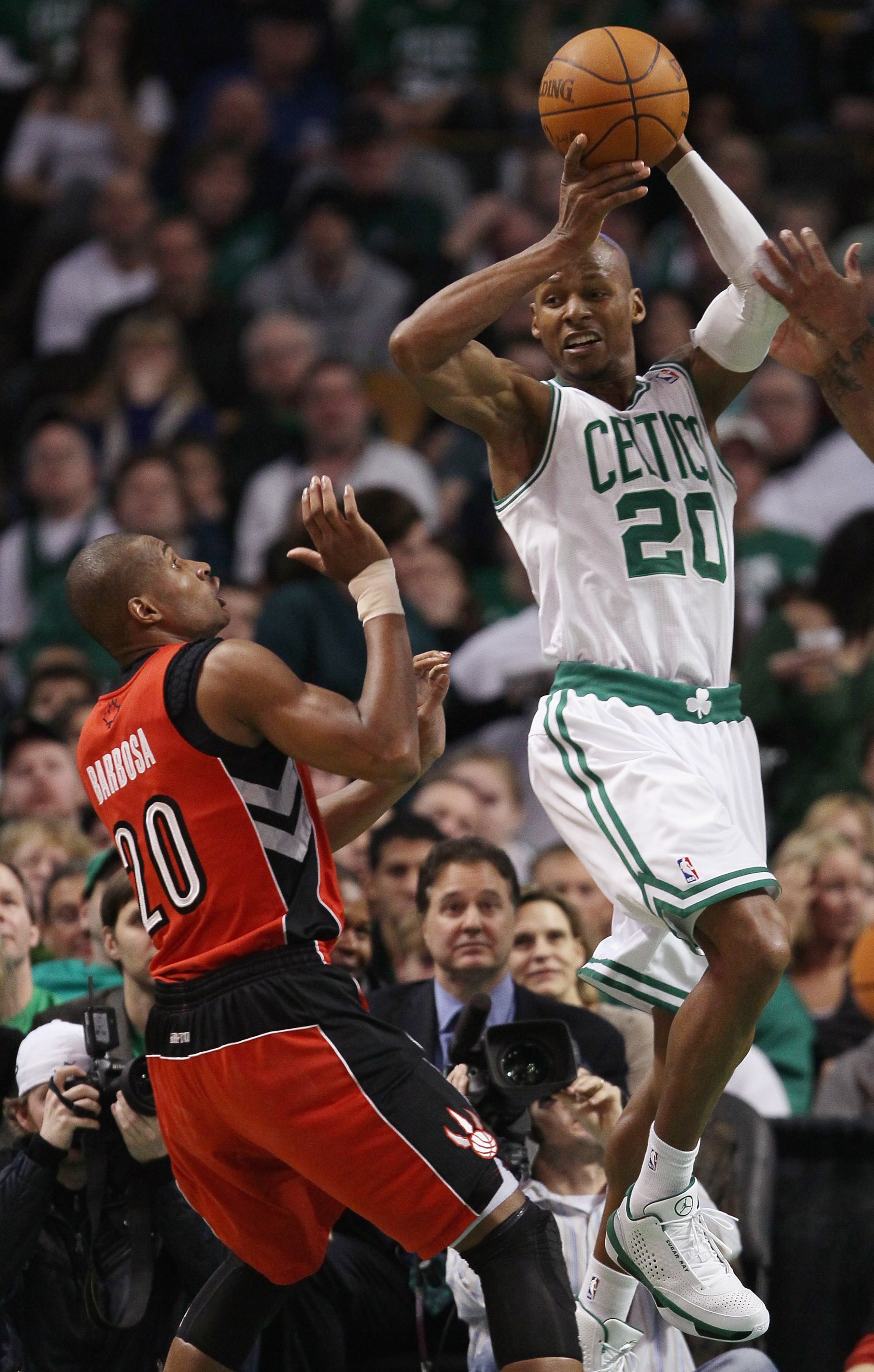 BOSTON, MA - JANUARY 07: Ray Allen #20 of the Boston Celtics passes the ball as Leandro Barbosa #20 of the Toronto Raptors defends on January 7, 2011 at the TD Garden in Boston, Massachusetts. The Celtics defeated the Raptors 122-102. NOTE TO USER: User BOSTON, MA - JANUARY 07: Ray Allen #20 of the Boston Celtics passes the ball as Leandro Barbosa #20 of the Toronto Raptors defends on January 7, 2011 at the TD Garden in Boston, Massachusetts. The Celtics defeated the Raptors 122-102. NOTE TO USER: User
