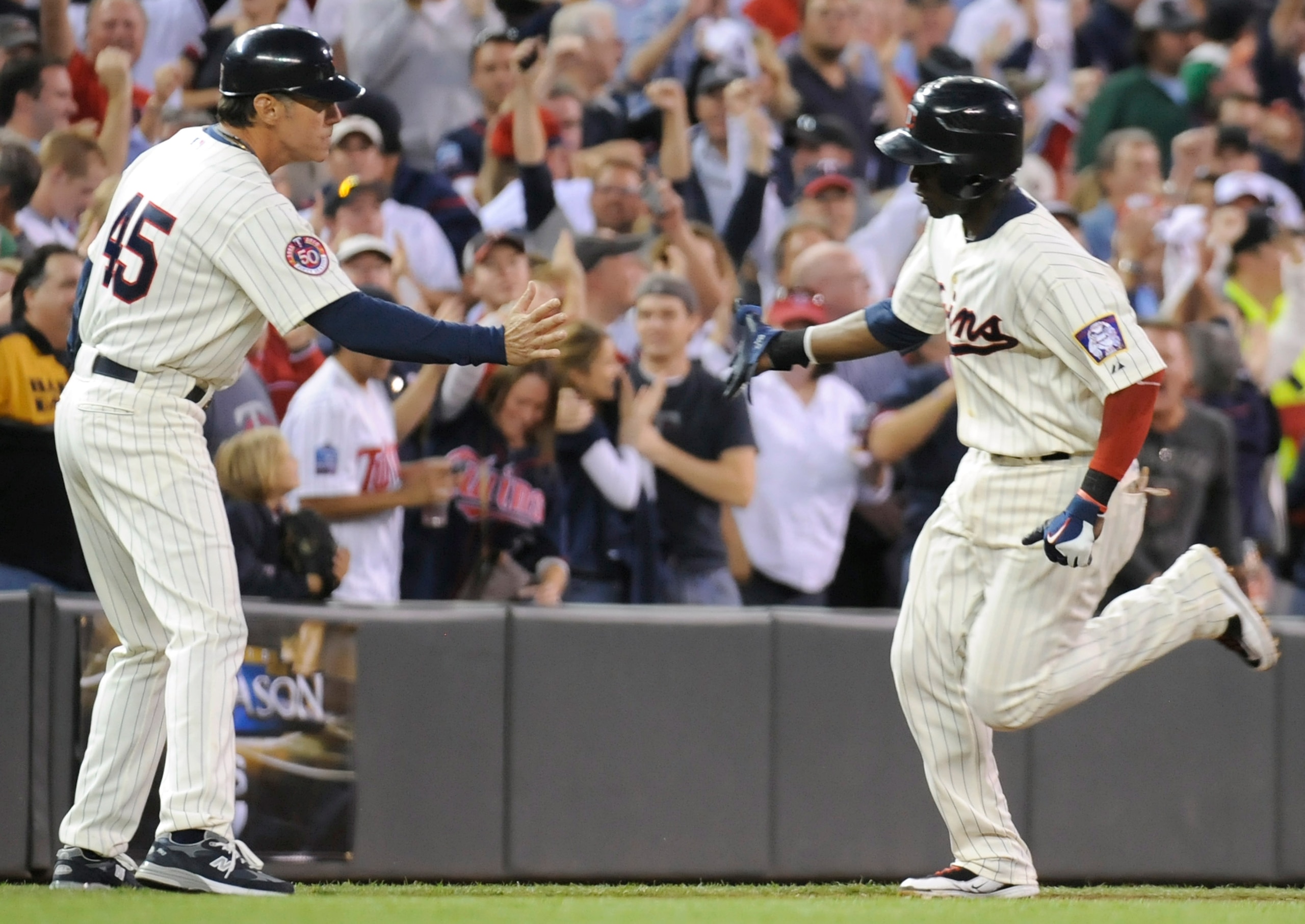 MINNEAPOLIS, MN - OCTOBER 7: Orlando Hudson #1 of the Minnesota Twins celebrates a solo home run with third base coach Scott Ullger #45 in the sixth inning during game two of the ALDS game against the Minnesota Twins on October 7, 2010 at Target Field in