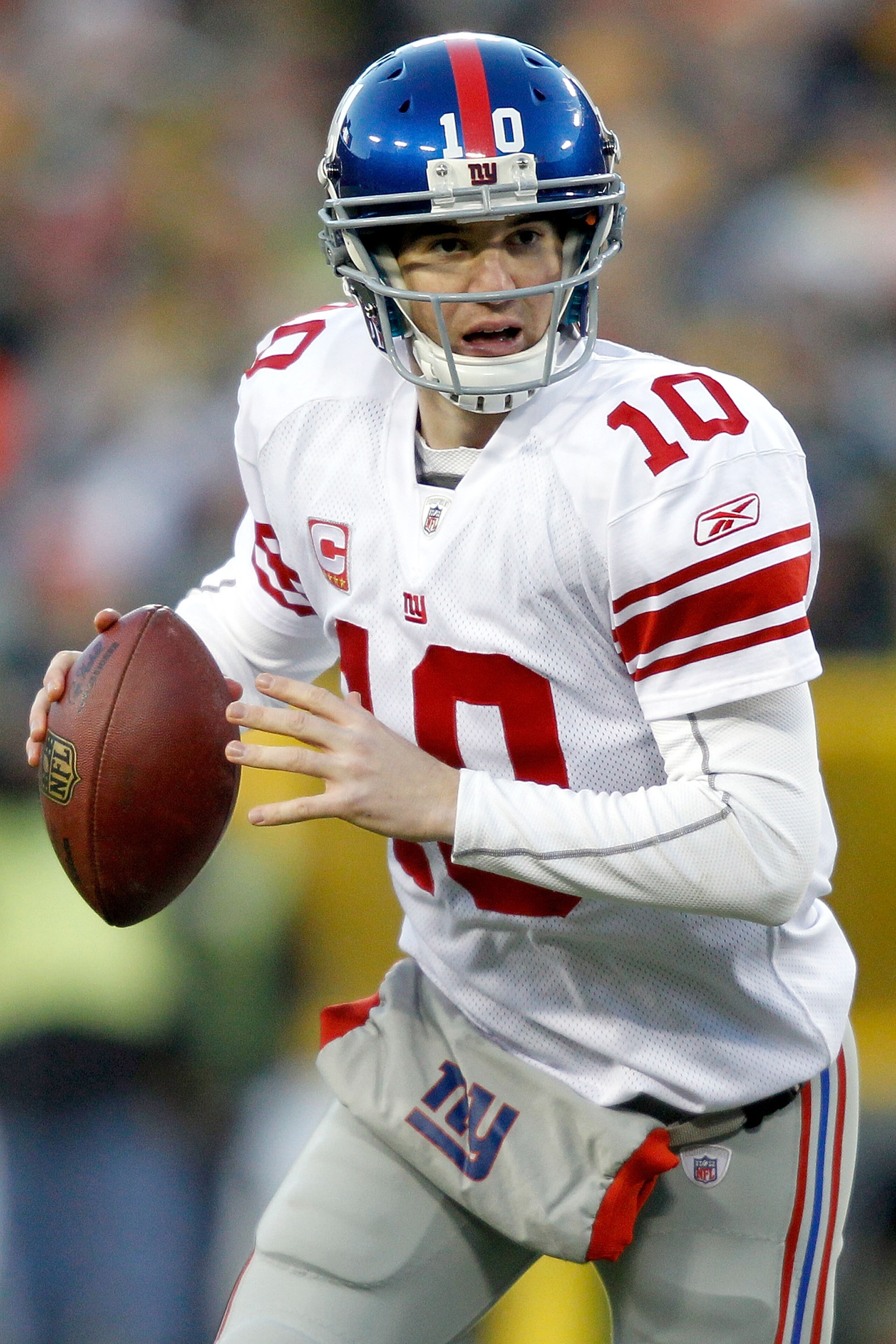 GREEN BAY, WI - DECEMBER 26: Eli Manning of the New York Giants rolls out of the pocket while playing the Green Bay Packers at Lambeau Field on December 26, 2010 in Green Bay, Wisconsin.  (Photo by Matthew Stockman/Getty Images)