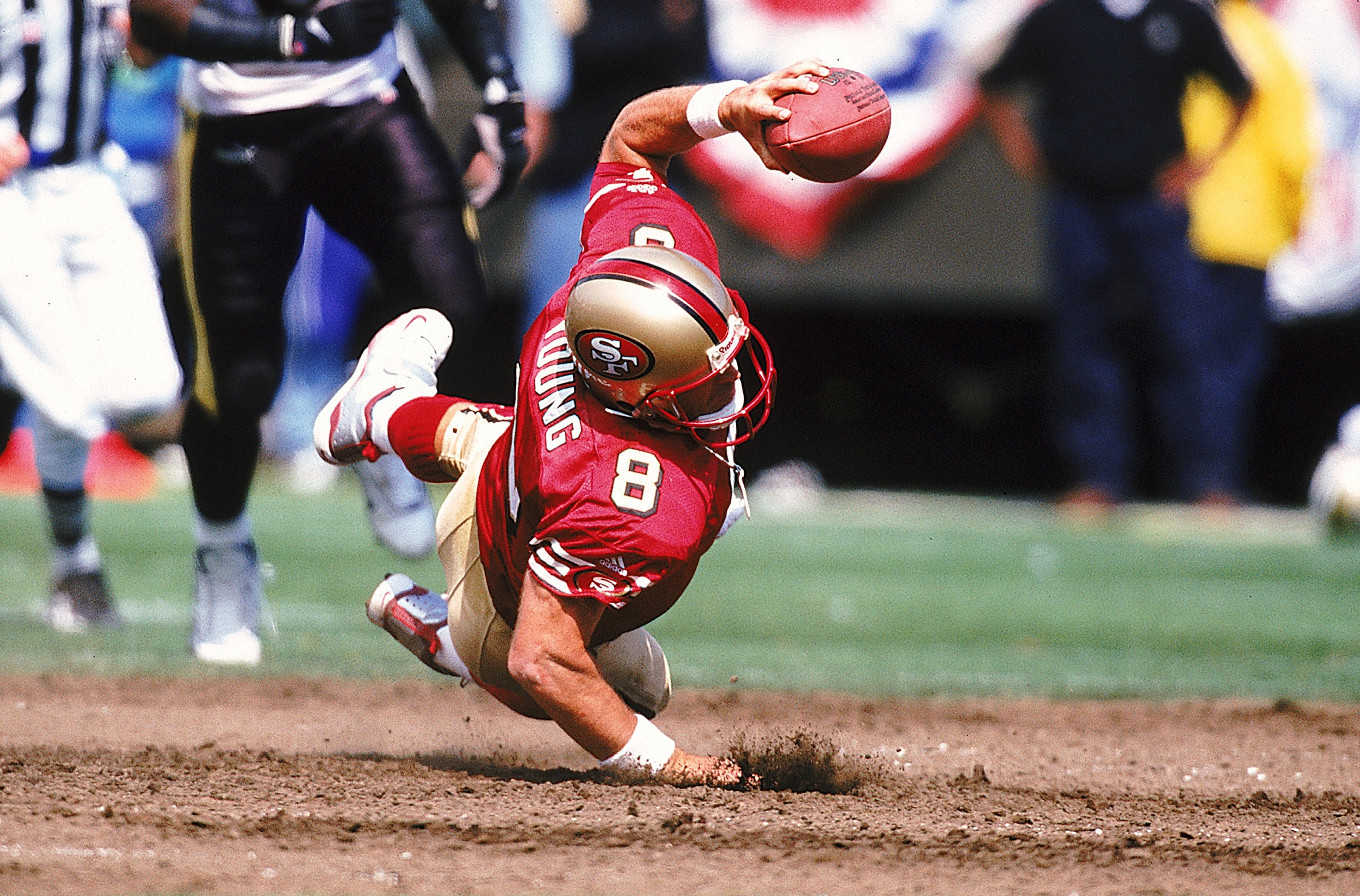 19 Sep 1999:  Steve Young #8 of the San Francisco 49ers falls with the ball during the game against the New Orleans Saints at 3 Com Park in San Francisco, California. The 49ers defeated the Saints 28-21. Mandatory Credit: Jed Jacobsohn  /Allsport