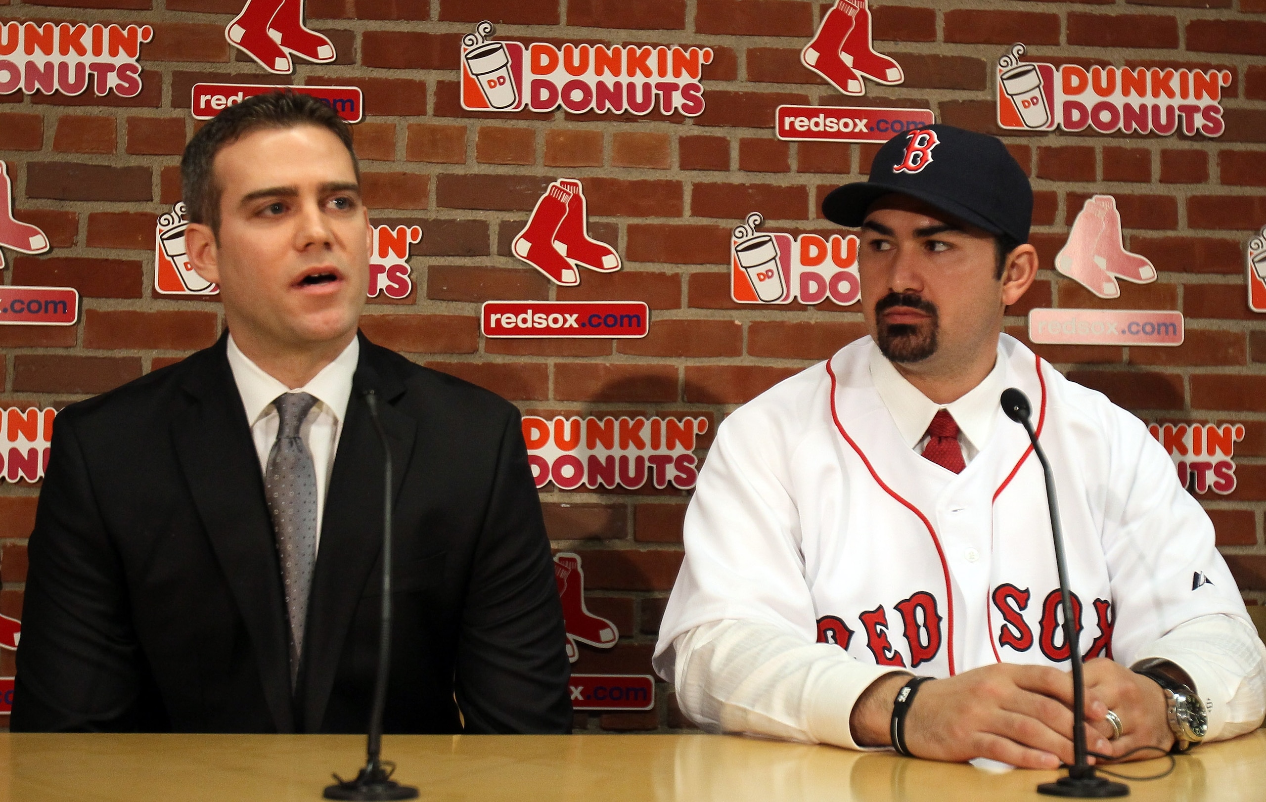 BOSTON, MA - DECEMBER 06:  Adrian Gonzalez (R) ooks on as General Manager Theo Epstein answers questions during a press conference to announce Gonzalez signing with the Boston Red Sox on December 6,  2010 at Fenway Park in Boston, Massachusetts.  (Photo b