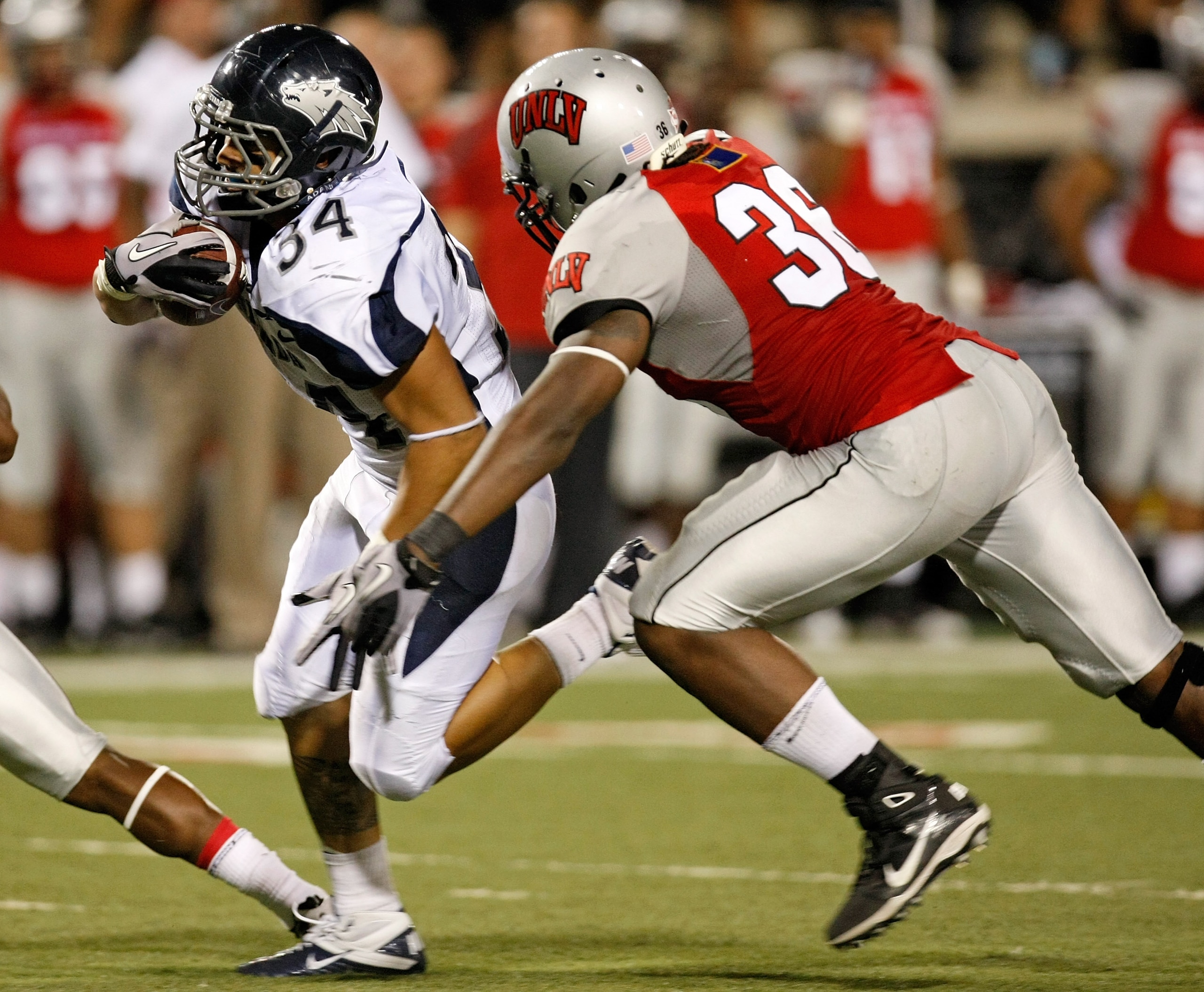 LAS VEGAS - OCTOBER 02:  Vai Taua #34 of the Nevada Reno Wolf Pack gets ahead of Ronnie Paulo #36 of the UNLV Rebels en route to scoring a touchdown in the second quarter of their game at Sam Boyd Stadium October 2, 2010 in Las Vegas, Nevada. Nevada Reno