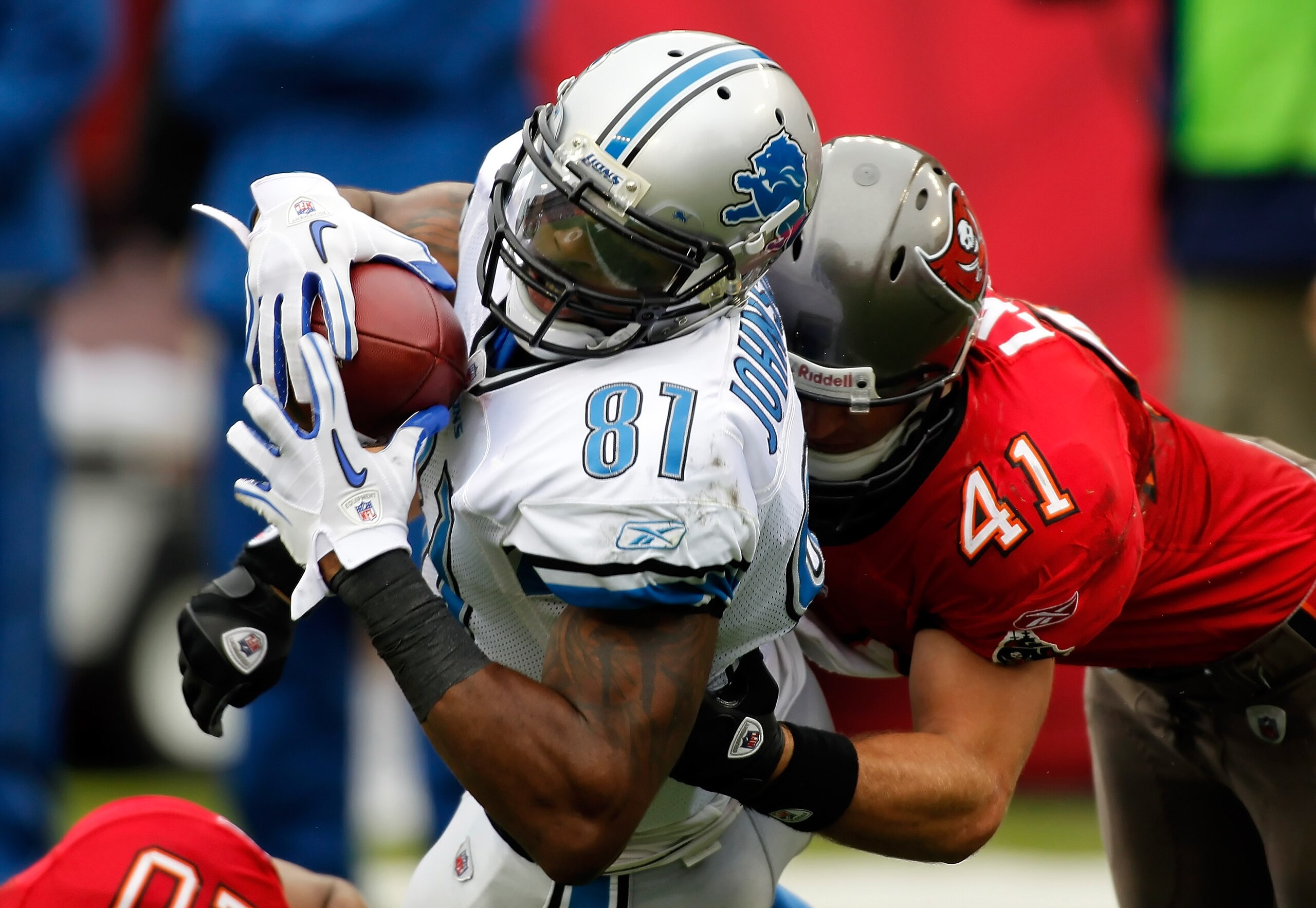 TAMPA, FL - DECEMBER 19:  Receiver Calvin Johnson #81 of the Detroit Lions stretches for additional yardage as safety Corey Lynch #41 of the Tampa Bay Buccaneers tackles him during the game at Raymond James Stadium on December 19, 2010 in Tampa, Florida. 