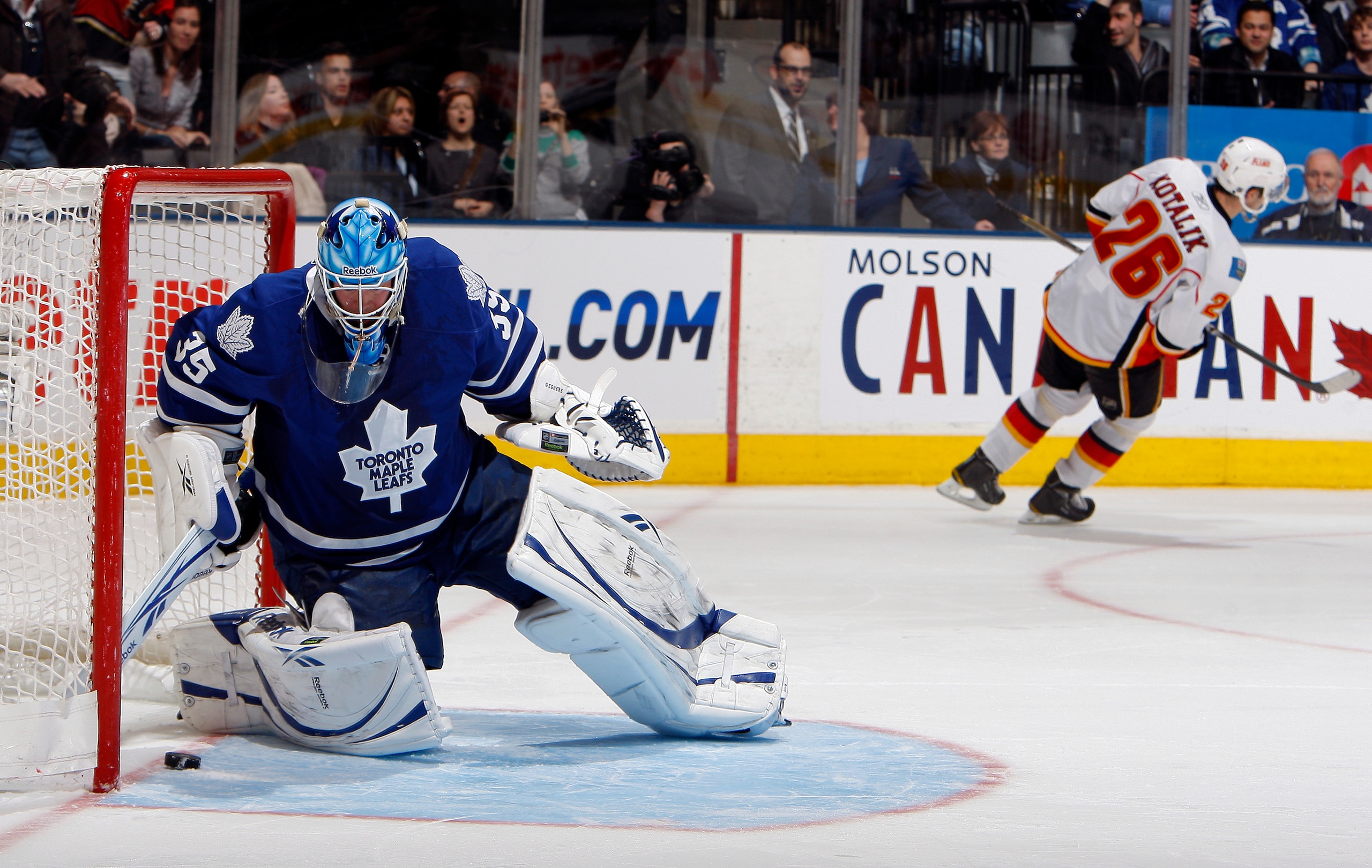 TORONTO, CANADA - JANUARY 15:  Jean-Sebastien Giguere #35 of the Toronto Maple Leafs scoops the puck out after Ales Kotalik #26 of the Calgary Flames scores during the shootout during game action at the Air Canada Centre January 15, 2011 in Toronto, Ontar