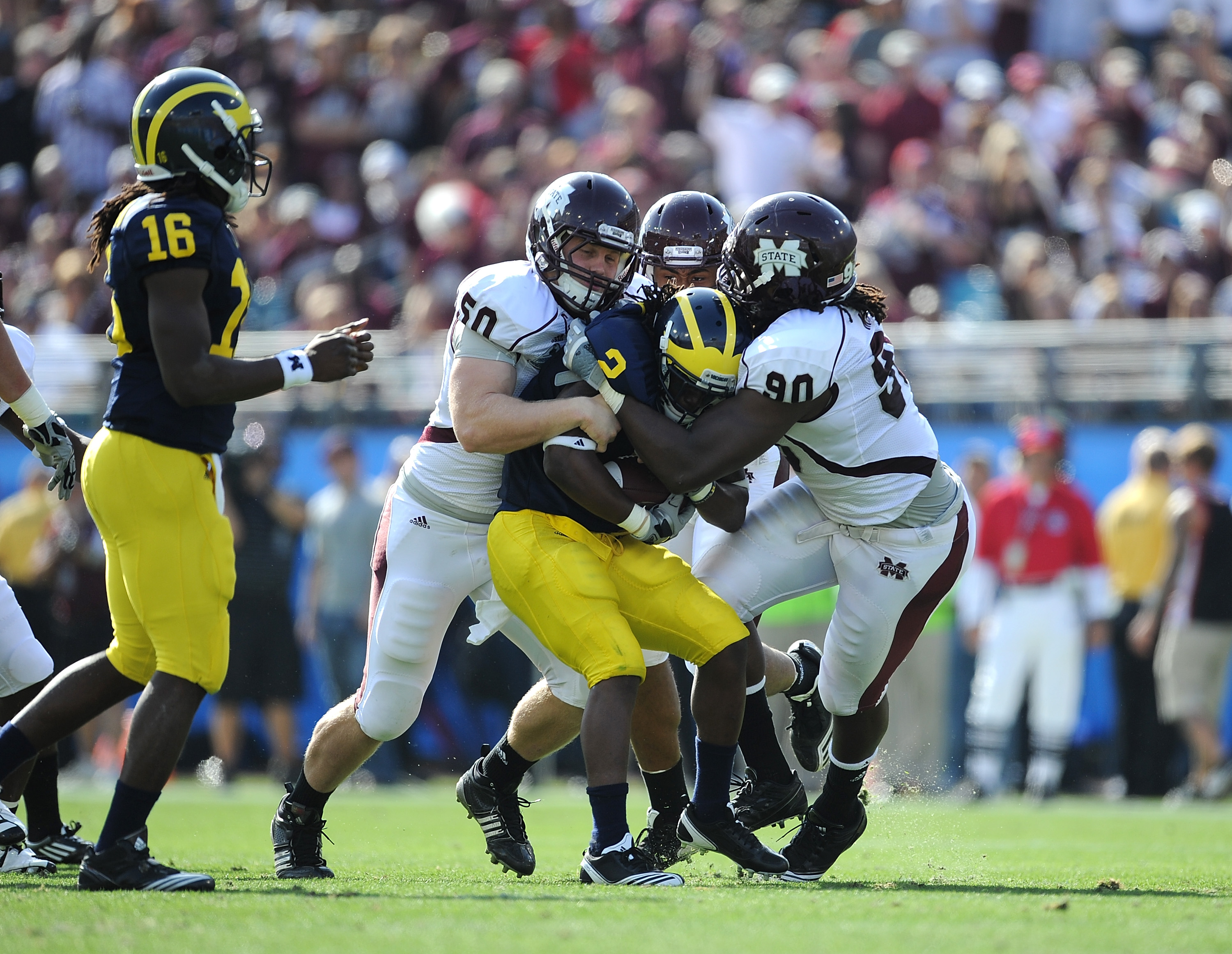 JACKSONVILLE, FL - JANUARY 01: Chris White #50 and Pernell McPhee #90 of the Mississippi State Bulldogs tackle Vincent Smith # 2 of the Michigan Wolverines during the Gator Bowl at EverBank Field on January 1, 2011 in Jacksonville, Florida (Photo by Ric