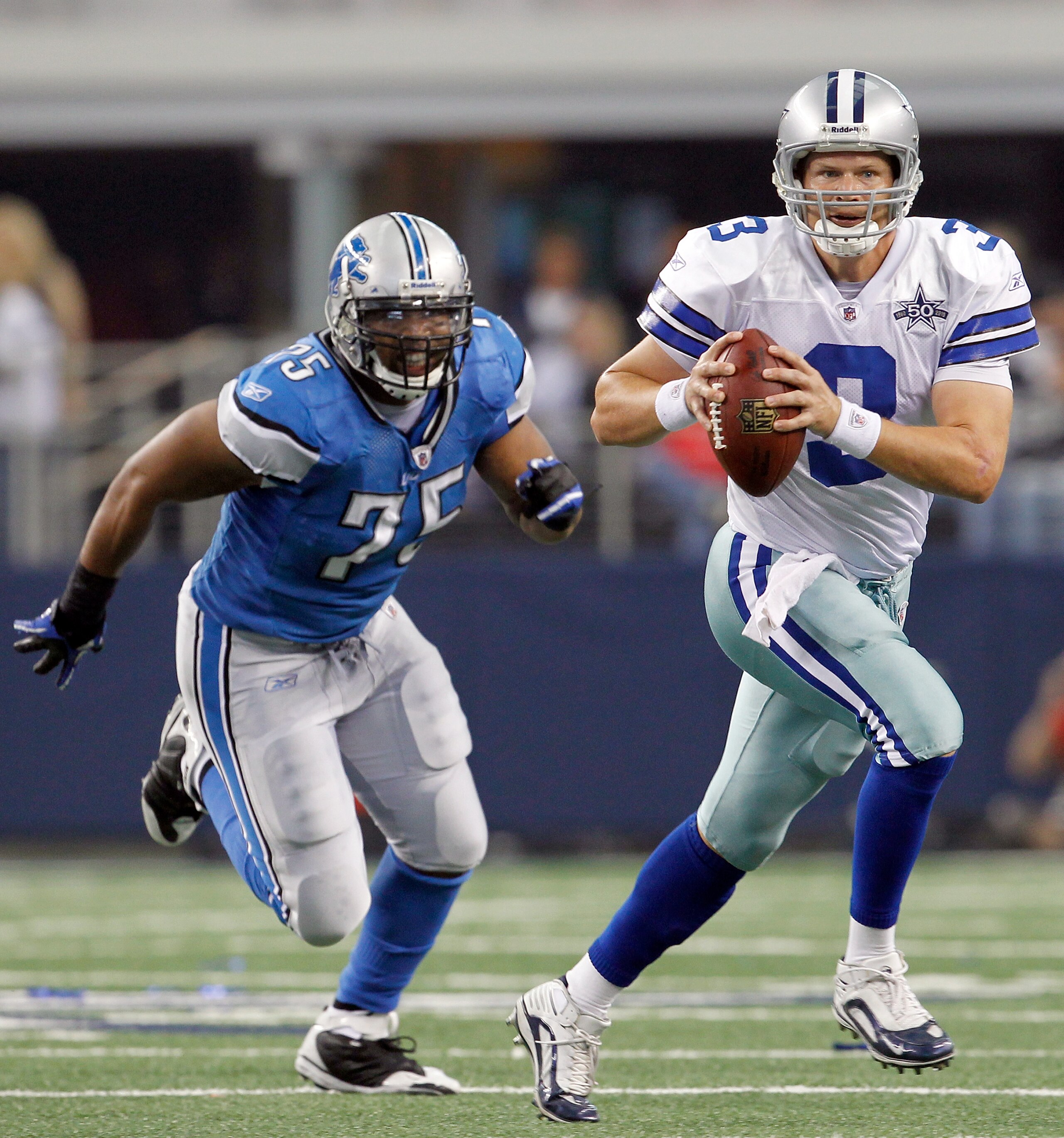 ARLINGTON, TX - NOVEMBER 21:  Quarterback Jon Kitna #3 of the Dallas Cowboys scrambles with the ball against defensive end Turk McBride #75 of the Detroit Lions at Cowboys Stadium on November 21, 2010 in Arlington, Texas.  The Cowboys beat the Lions 35-19