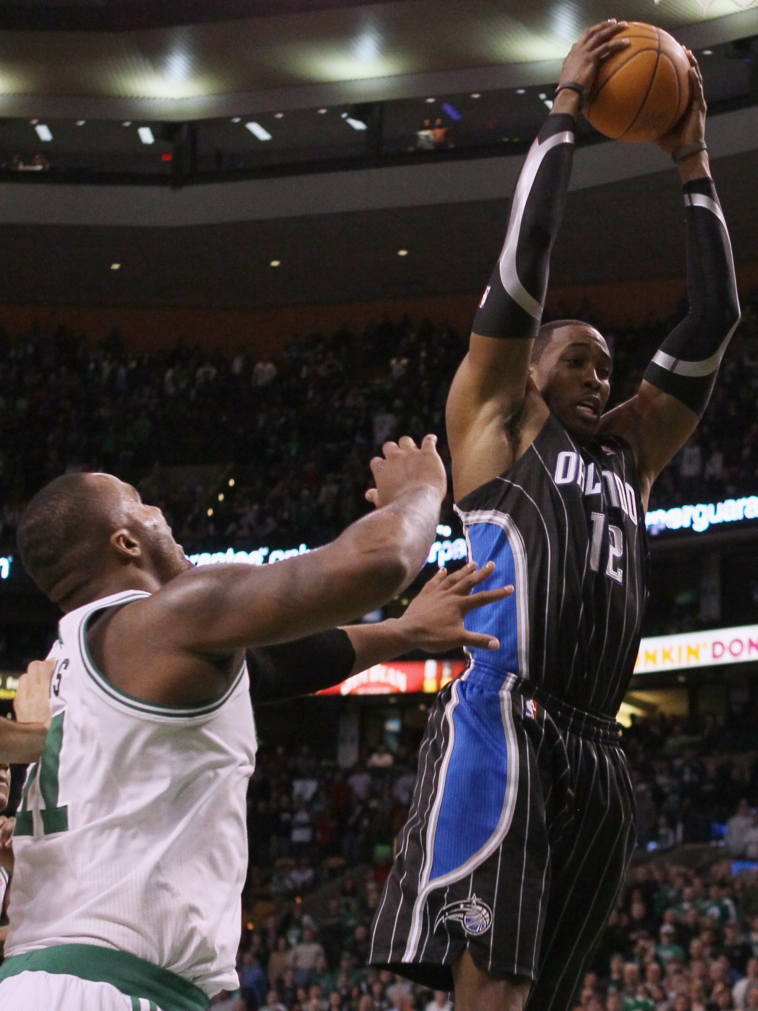 BOSTON, MA - JANUARY 17:   Dwight Howard #12 of the Orlando Magic grabs the rebound before Glen Davis #11 of the Boston Celtics on January 17, 2011 at the TD Garden in Boston, Massachusetts. The Celtics defeated the Magic 109-106.  NOTE TO USER: User expr