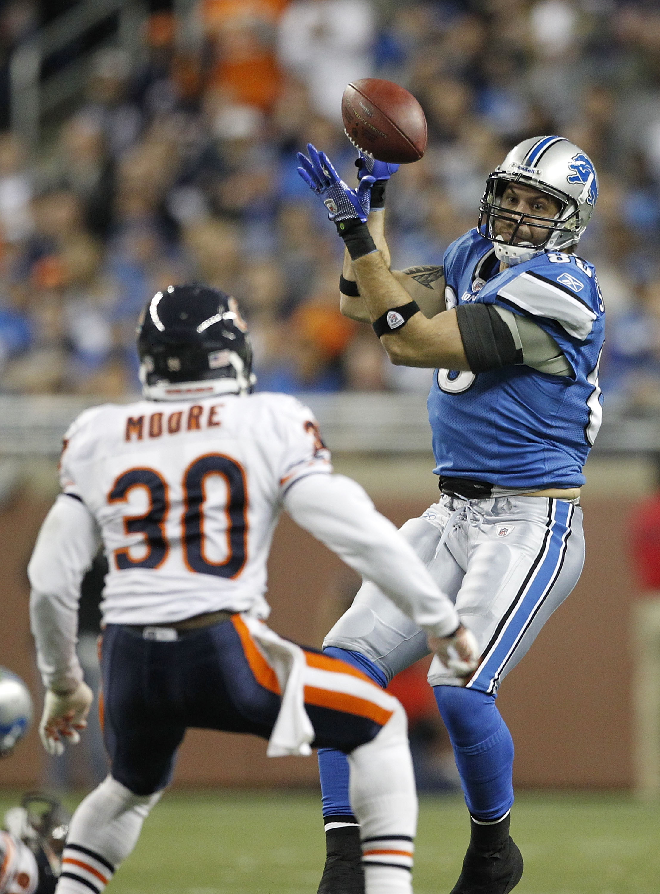 DETROIT - DECEMBER 05: Tony Scheffler #85 of the Detroit Lions makes a catch as D. J. Moore #30 of the Chicago Bears defends during the fourth quarter of the game at Ford Field on December 5, 2010 in Detroit, Michigan. The Bears defeated the Lions 24-20.