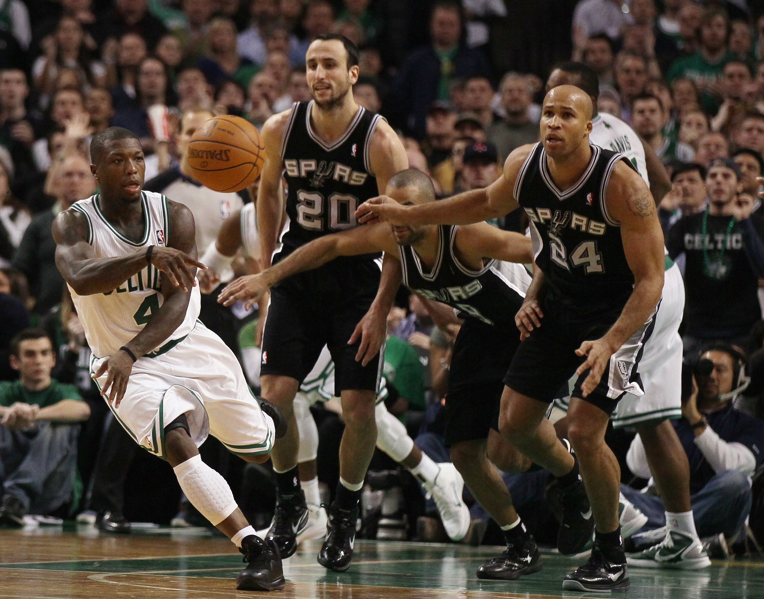 BOSTON, MA - JANUARY 05:  Nate Robinson #4 of the Boston Celtics avoids getting fouled by Tony Parker #9,Manu Ginobili #20 and Richard Jefferson #24 of the San Antonio Spurs on January 5, 2011 at the TD Garden in Boston, Massachusetts. The Celtics defeate