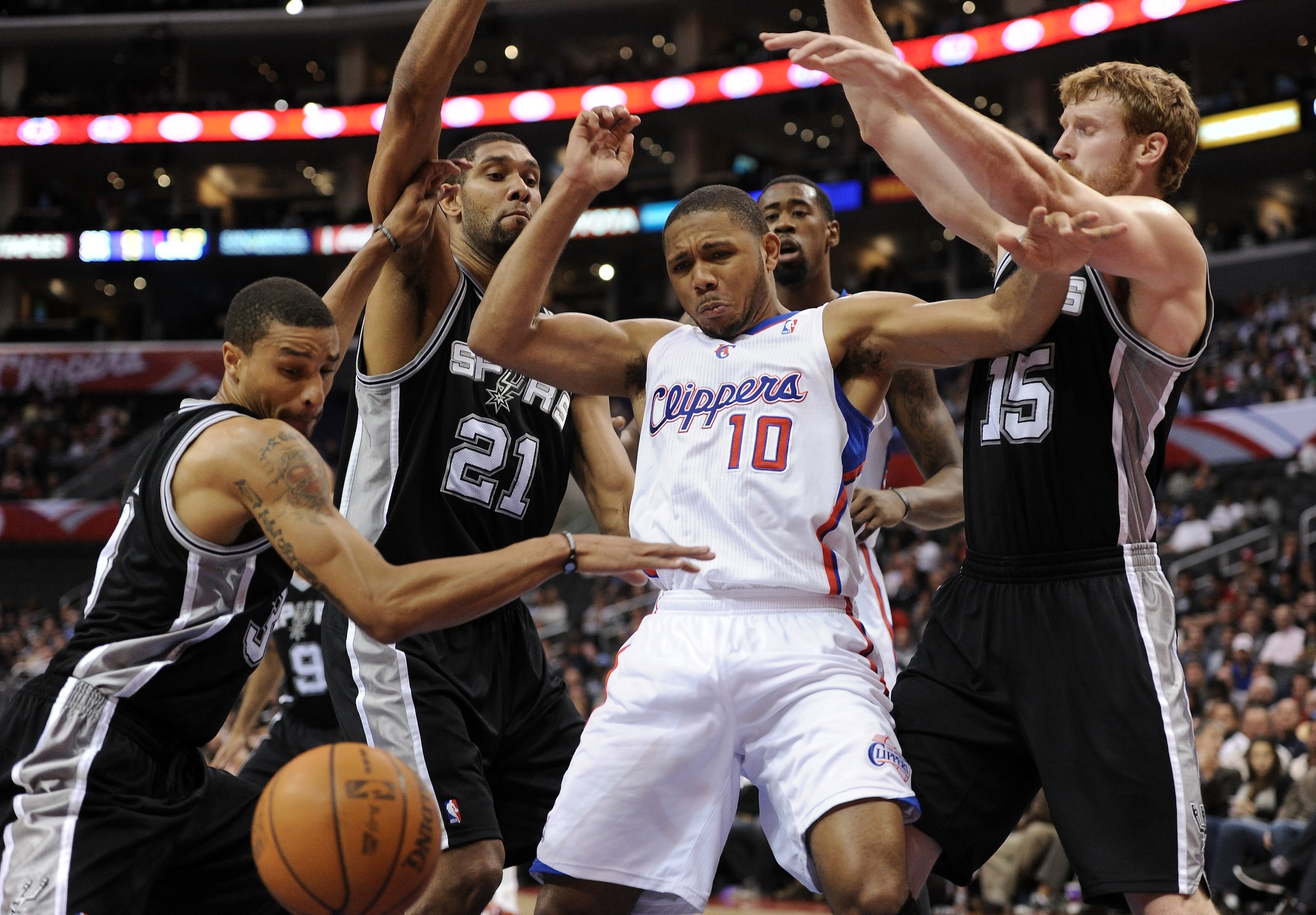 LOS ANGELES, CA - DECEMBER 01:  Eric Gordon #10 of the Los Angeles Clippers has the ball knocked away by Tim Duncan #21, Matt Bonner #15 and George Hill #3 of the San Antonio Spurs Los Angeles at the Staples Center on December 1, 2010 in Los Angeles, Cali