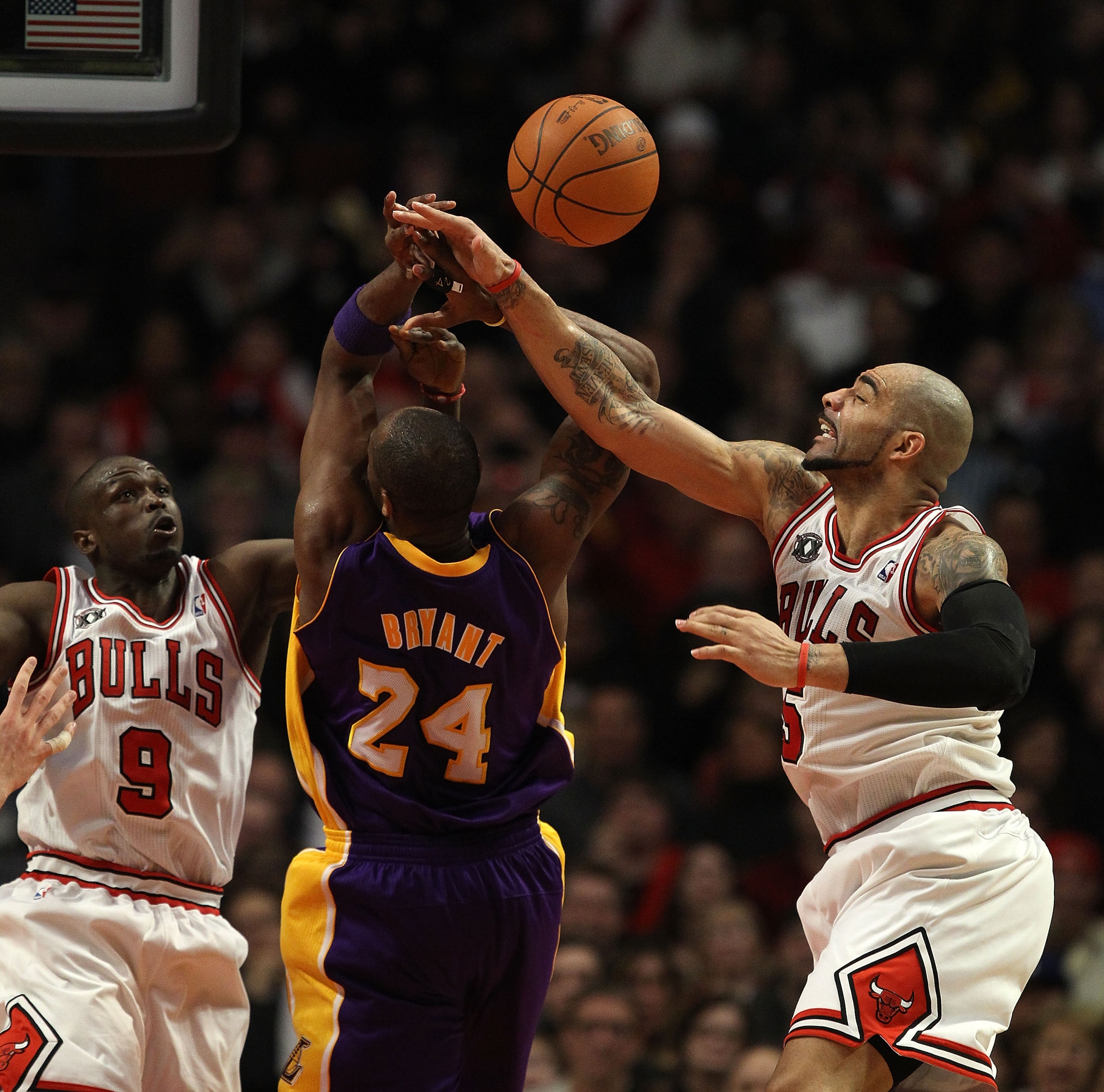 CHICAGO, IL - DECEMBER 10: Carlos Boozer #5 of the Chicago Bulls knocks the ball away from Kobe Bryant #24 of the Los Angeles Lakers as Luol Deng #9 also defends at the United Center on December 10, 2010 in Chicago, Illinois. The Bulls defeated the Lakers CHICAGO, IL - DECEMBER 10: Carlos Boozer #5 of the Chicago Bulls knocks the ball away from Kobe Bryant #24 of the Los Angeles Lakers as Luol Deng #9 also defends at the United Center on December 10, 2010 in Chicago, Illinois. The Bulls defeated the Lakers