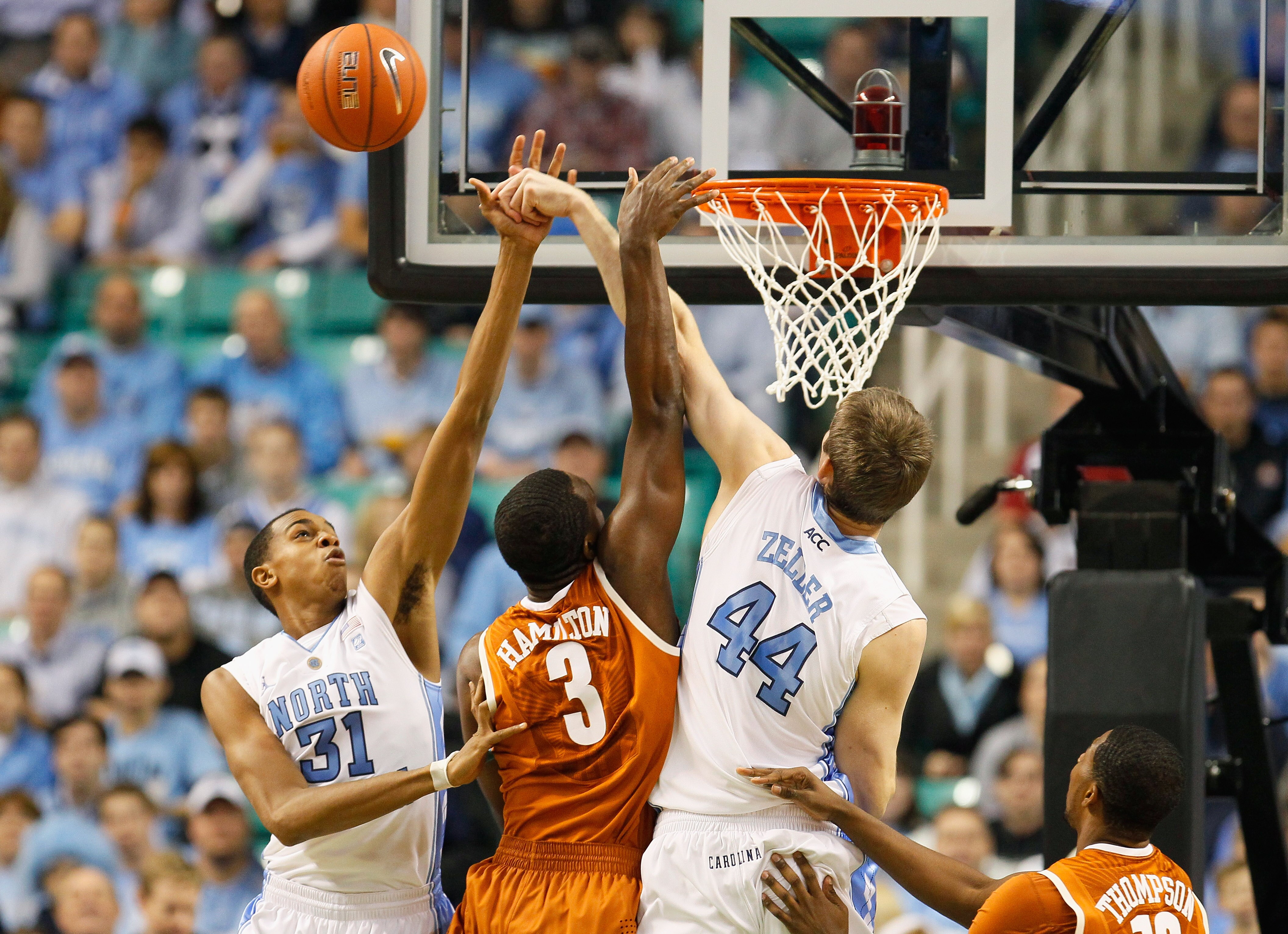 GREENSBORO, NC - DECEMBER 18:  Tyler Zeller #44 and John Henson #31 of the North Carolina Tar Heels block a shot by Jordan Hamilton #3 of the Texas Longhorns at Greensboro Coliseum on December 18, 2010 in Greensboro, North Carolina.  (Photo by Kevin C. Co