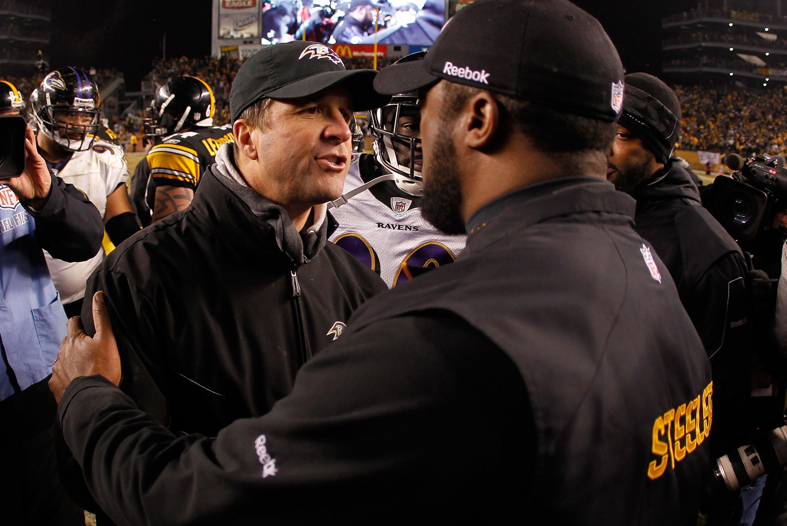 PITTSBURGH, PA - JANUARY 15:  (R-L) Head coach Mike Tomlin of the Pittsburgh Steelers speaks with head coach John Harbaugh of the Baltimore Ravens following the AFC Divisional Playoff Game at Heinz Field on January 15, 2011 in Pittsburgh, Pennsylvania. Th