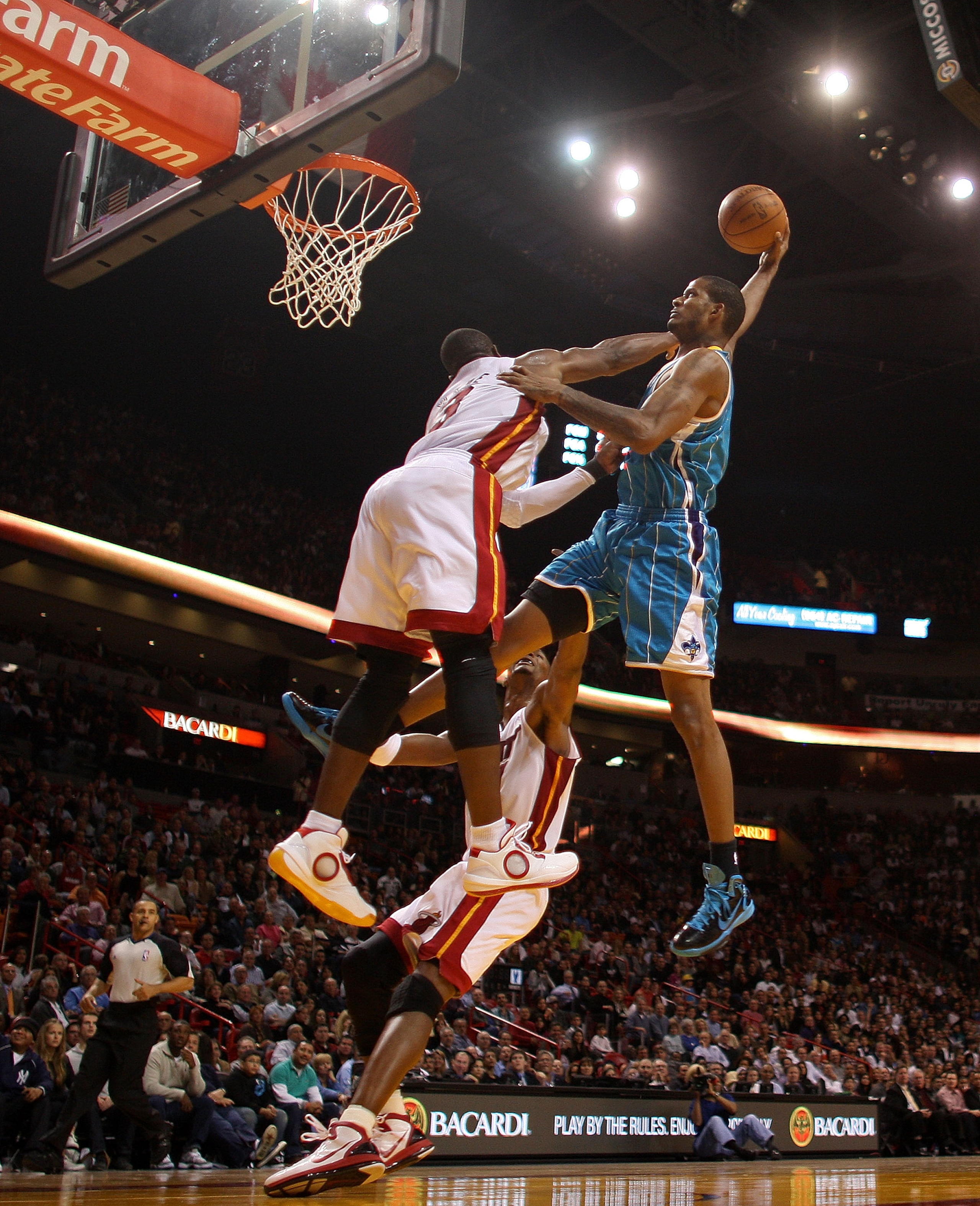 MIAMI, FL - DECEMBER 13:  Trevor Ariza #1 of the New Orleans Hornets dunks over Dwyane Wade #3 of the Miami Heat during a foul shot during a game at American Airlines Arena on December 13, 2010 in Miami, Florida. NOTE TO USER: User expressly acknowledges