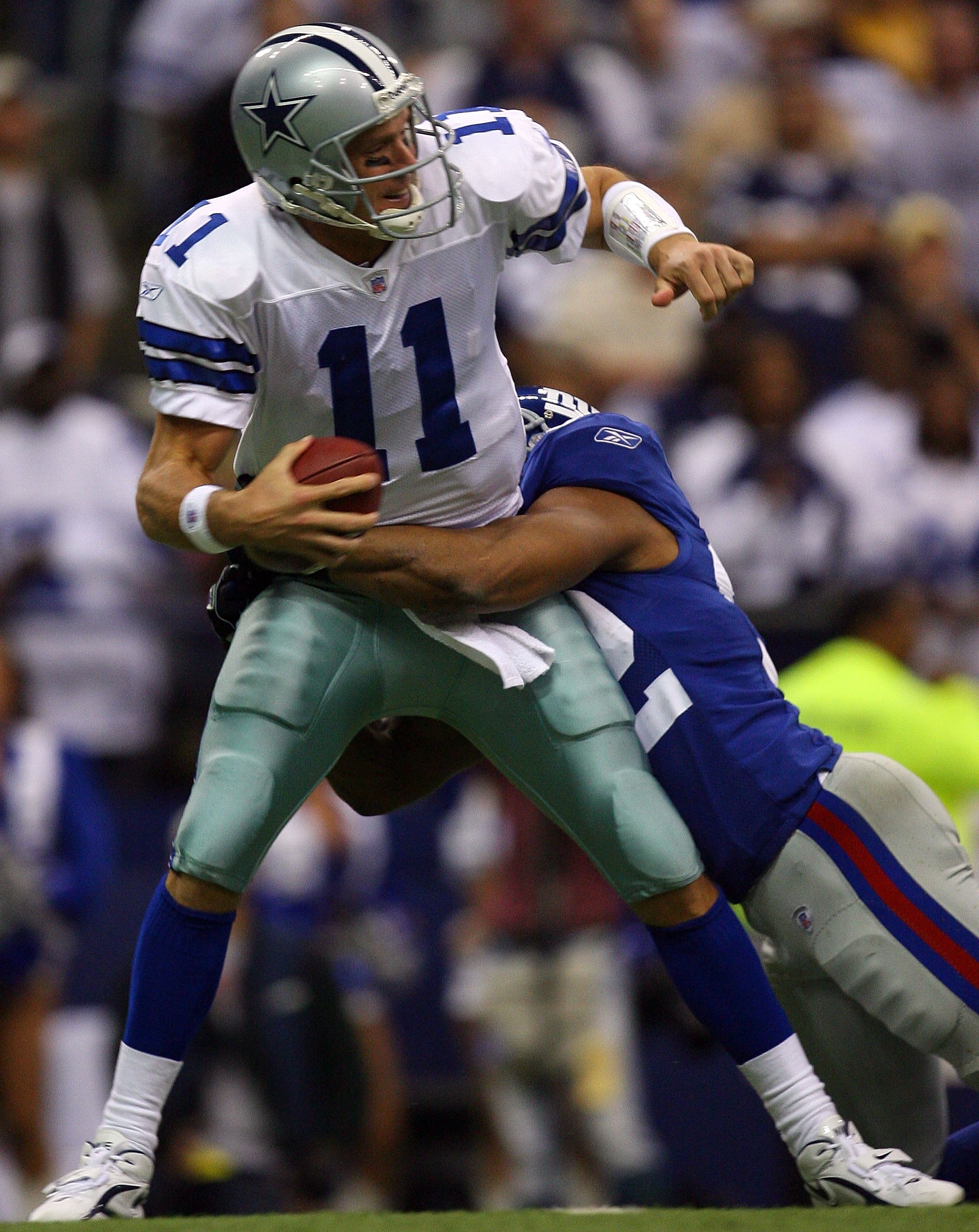 Dallas Cowboys Tony Romo gets pressured by New York Giants Michael Strahan  in the second half of their playoff game January 13, 2008 at Texas Stadium  in Irving, TX. The Giants beat