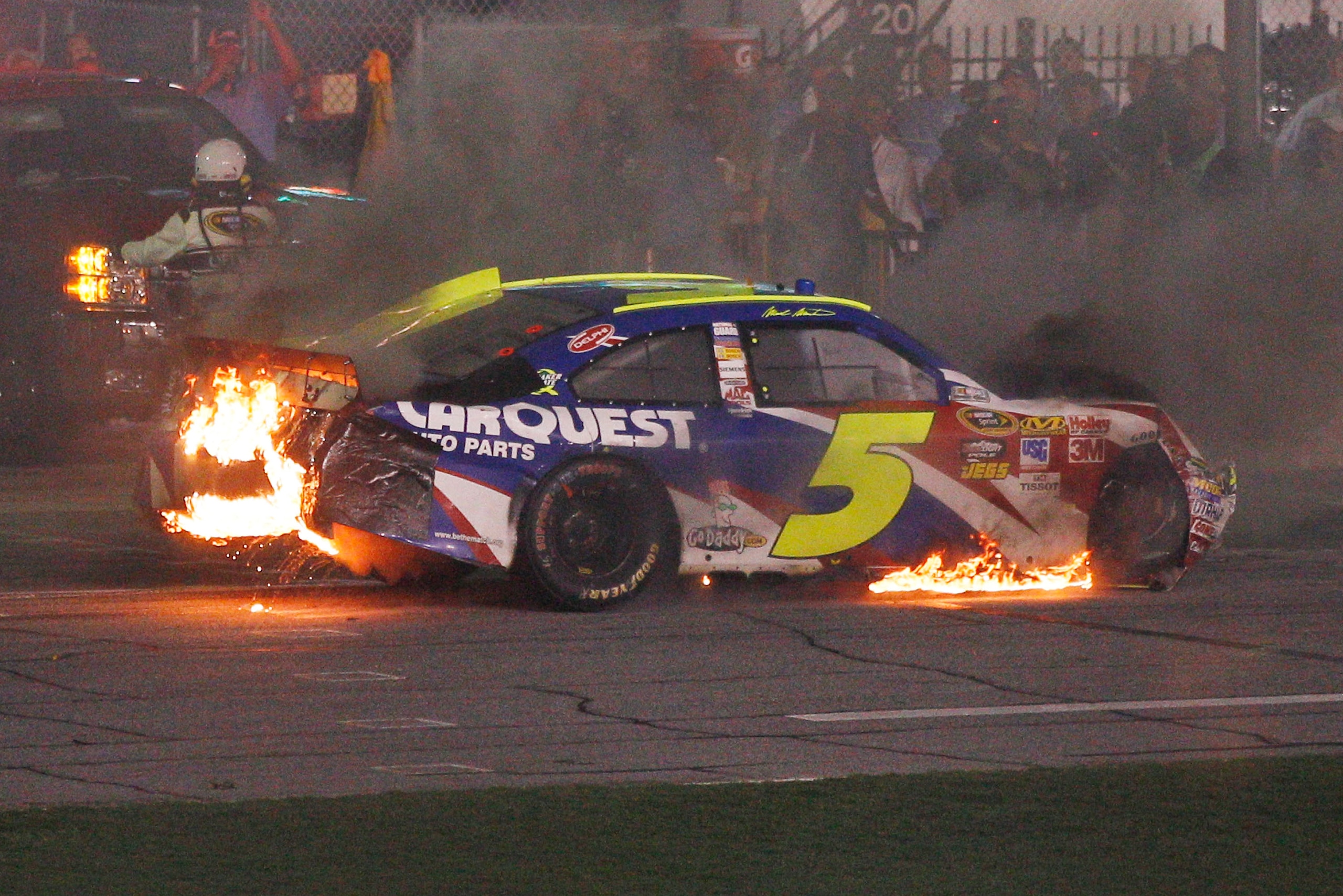 DAYTONA BEACH, FL - JULY 03:  Mark Martin, driver of the #5 CARQUEST Auto Parts/GoDaddy.com Chevrolet, drives down pit road on fire during the NASCAR Sprint Cup Series Coke Zero 400 at Daytona International Speedway on July 3, 2010 in Daytona Beach, Flori