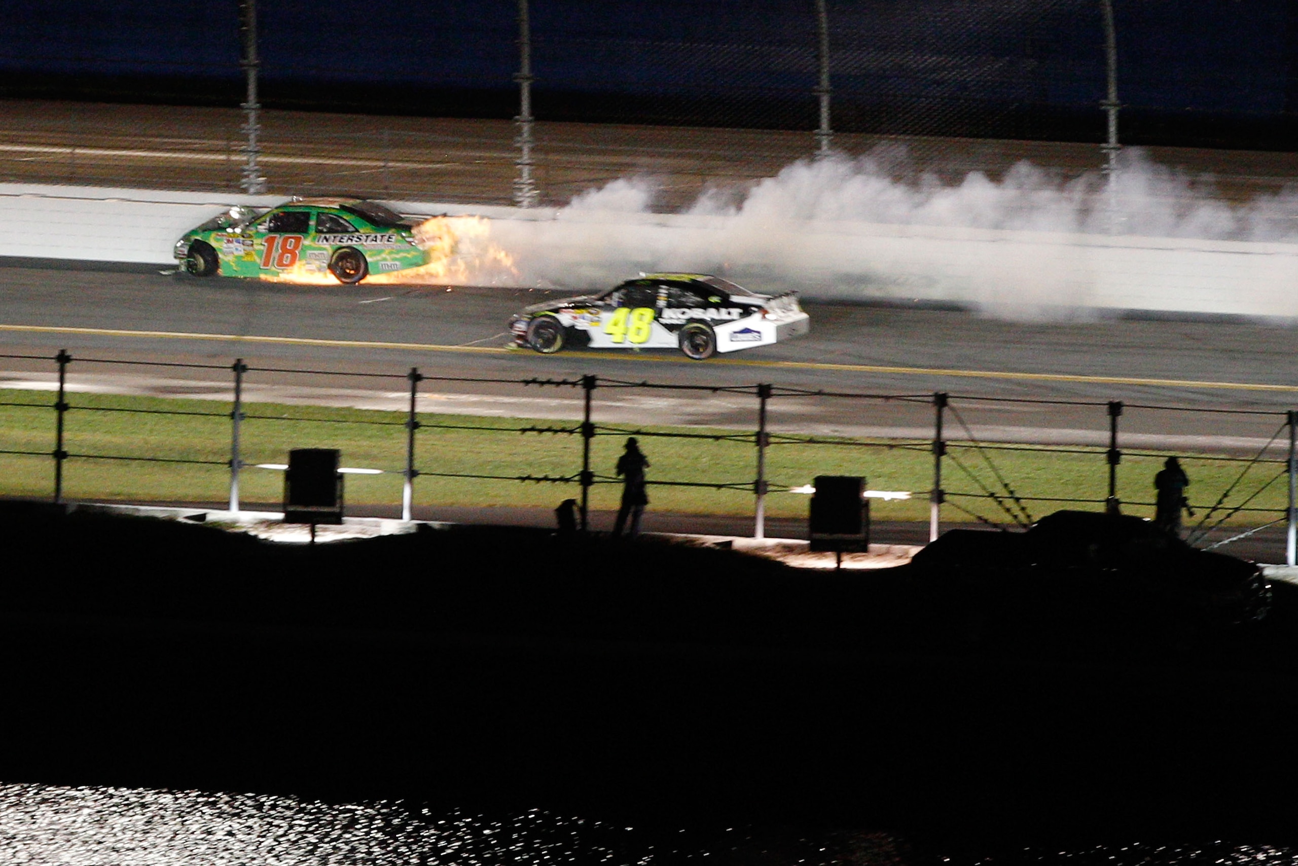 DAYTONA BEACH, FL - JULY 03:  Kyle Busch, driver of the #18 Interstate Batteries Toyota, crashes into the wall near Jimmie Johnson, driver of the #48 Lowe's/KOBALT Tools Chevrolet, during the NASCAR Sprint Cup Series Coke Zero 400 at Daytona International