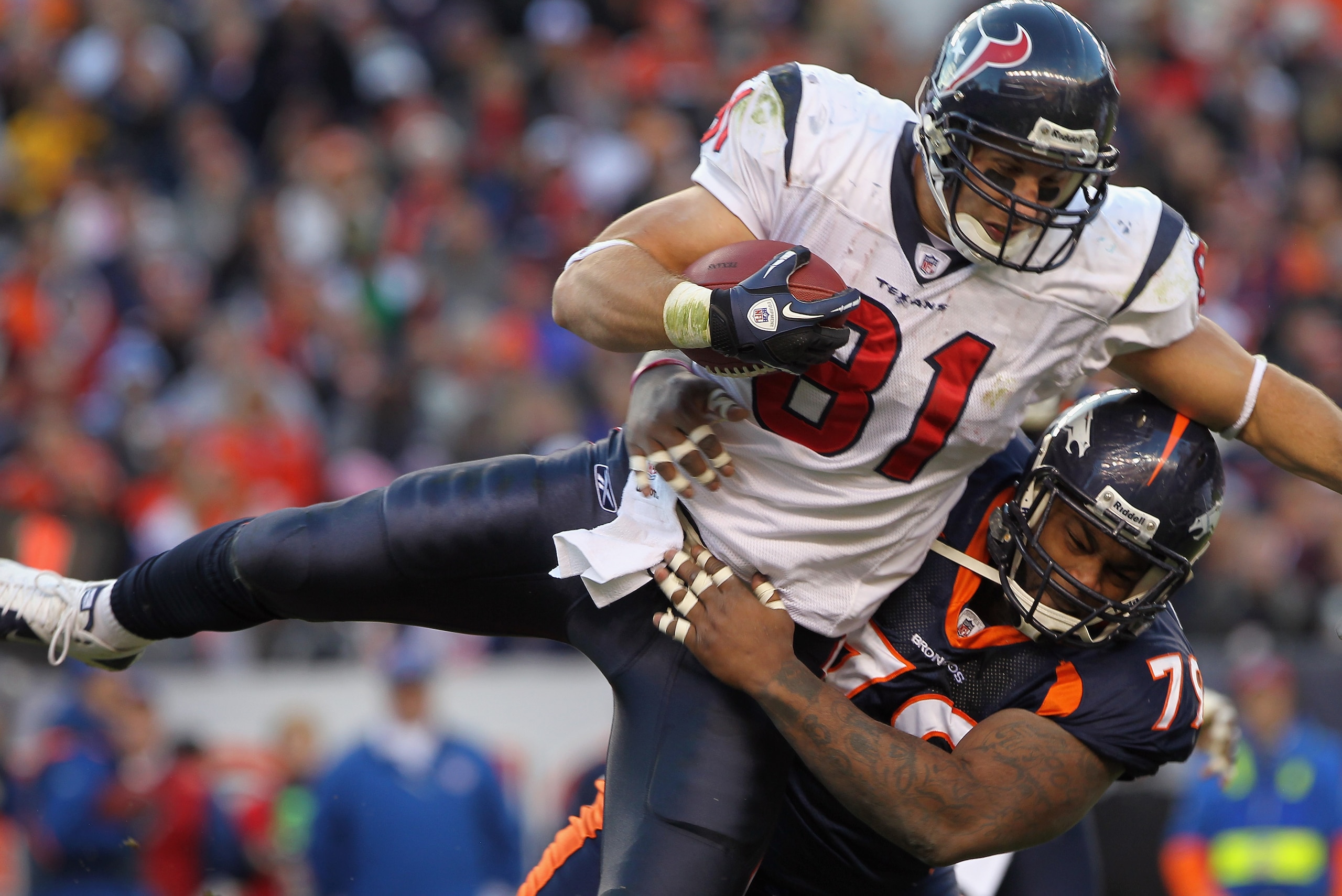 DENVER - DECEMBER 26:  Wide receiver Owen Daniels #81 of the Houston Texas makes a reception and is tackled by defensive lineman Marcus Thomas #79 of the Denver Broncos at INVESCO Field at Mile High on December 26, 2010 in Denver, Colorado. The Broncos de