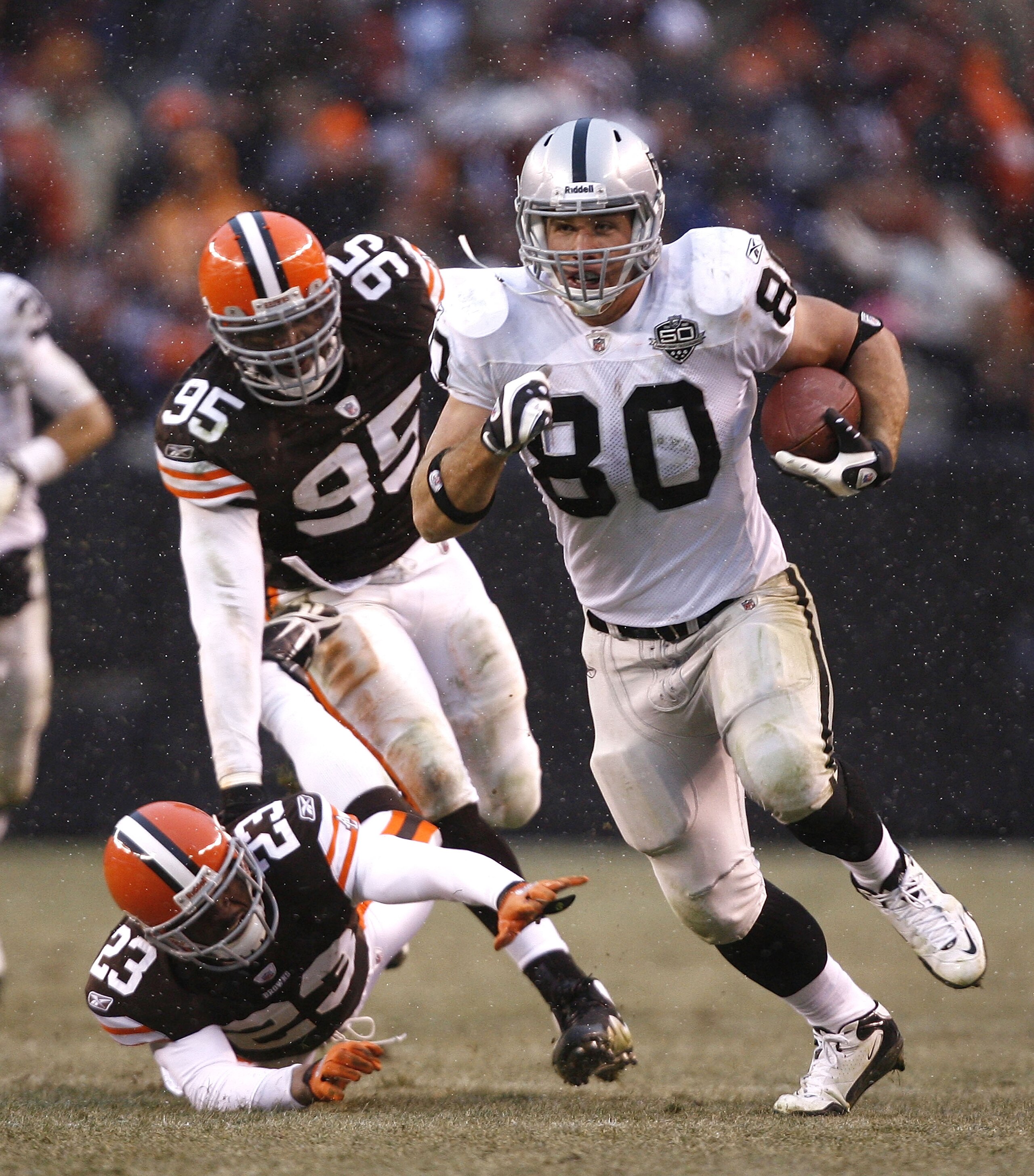 CLEVELAND - DECEMBER 27:  Zach Miller #80 of the Oakland Raiders runs by Hank Poteat #23 and Kamerion Wimbley #95 of the Cleveland Browns at Cleveland Browns Stadium on December 27, 2009 in Cleveland, Ohio.  (Photo by Matt Sullivan/Getty Images)