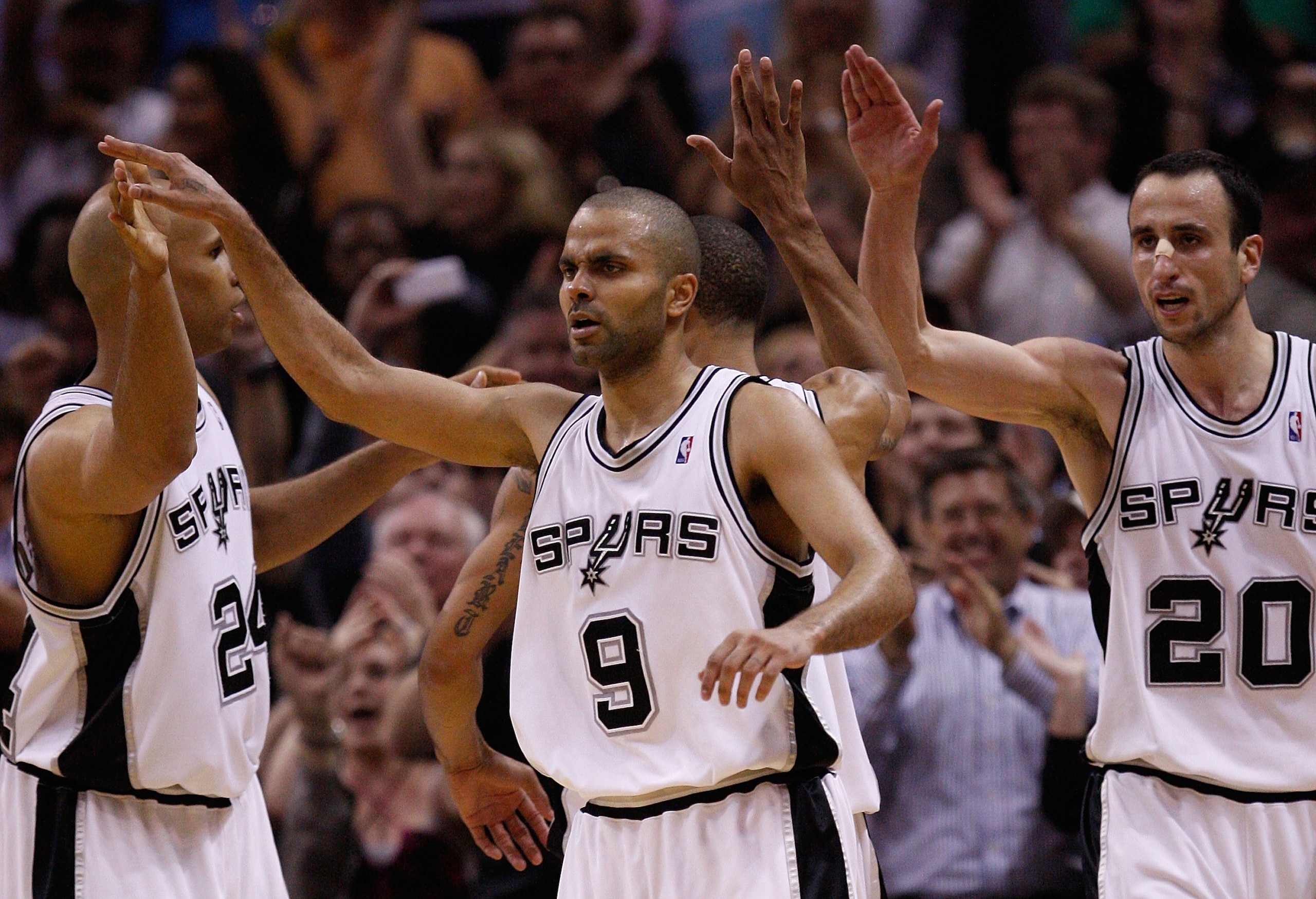 SAN ANTONIO - APRIL 23:  Tony Parker #9 of the San Antonio Spurs reacts with Richard Jefferson #24 and Manu Ginobili #20 against the Dallas Mavericks in Game Three of the Western Conference Quarterfinals during the 2010 NBA Playoffs at AT&T Center on Apri